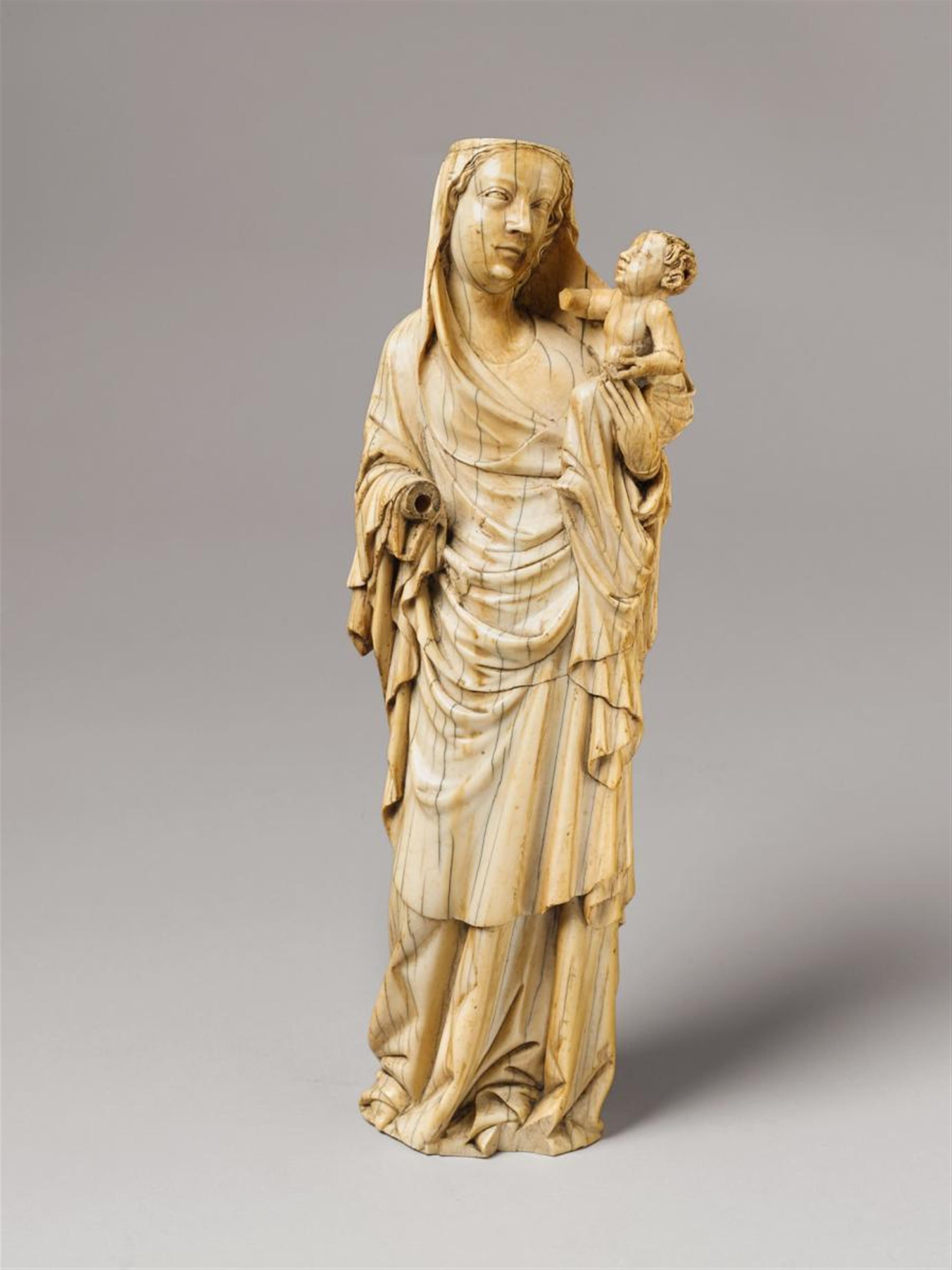 A 14TH CENTURY MAASLAND IVORY FIGURE OF THE MADONNA AND CHILD - image-1
