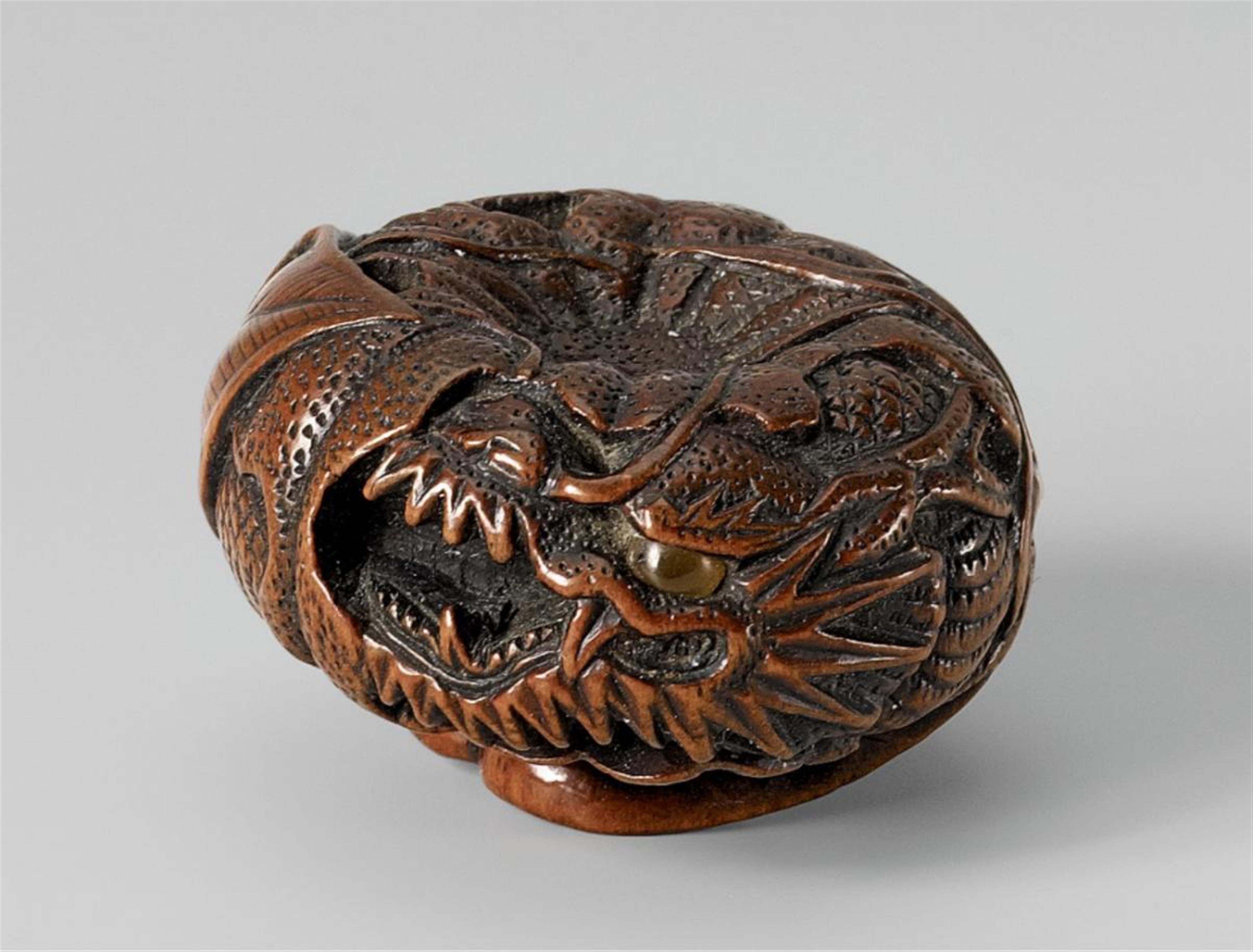 A fine Tanba school boxwood netsuke of a dragon in a mandarin. Mid 19th century - image-1