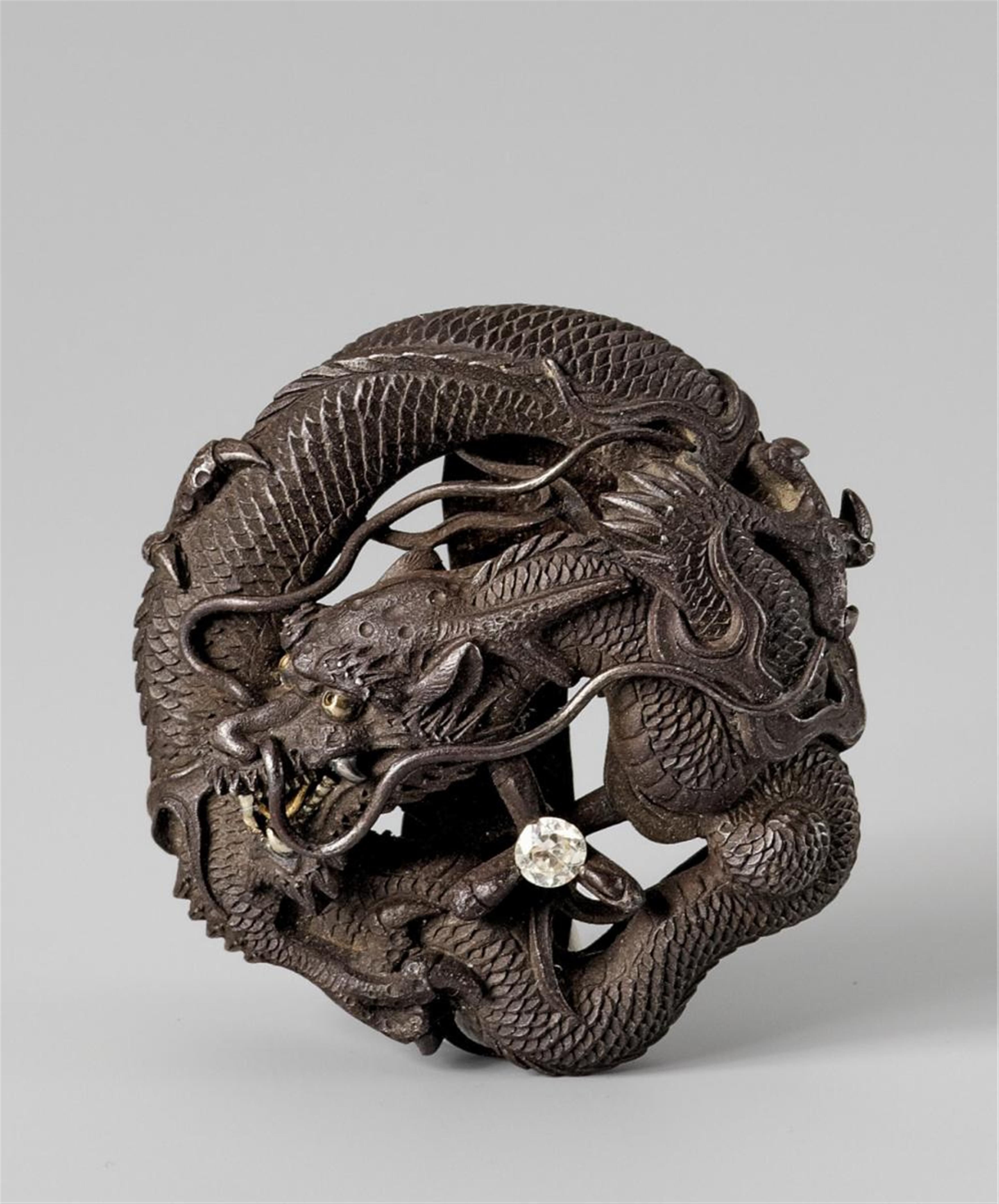 A wrought russet iron ryûsa manjû-type ornament in the shape of a coiled dragon, by Toshitsugu. Late 19th century - image-1
