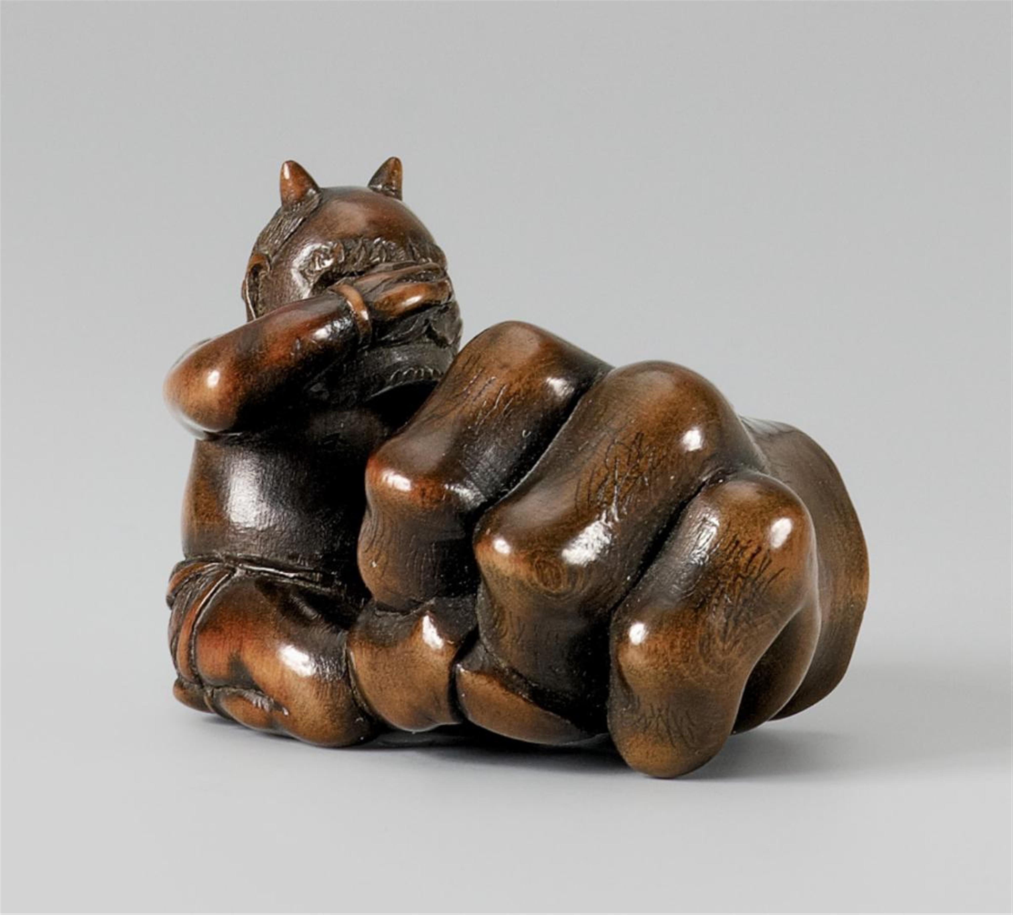 A wood netsuke of an oni and a huge claw. Late 19th century - image-1