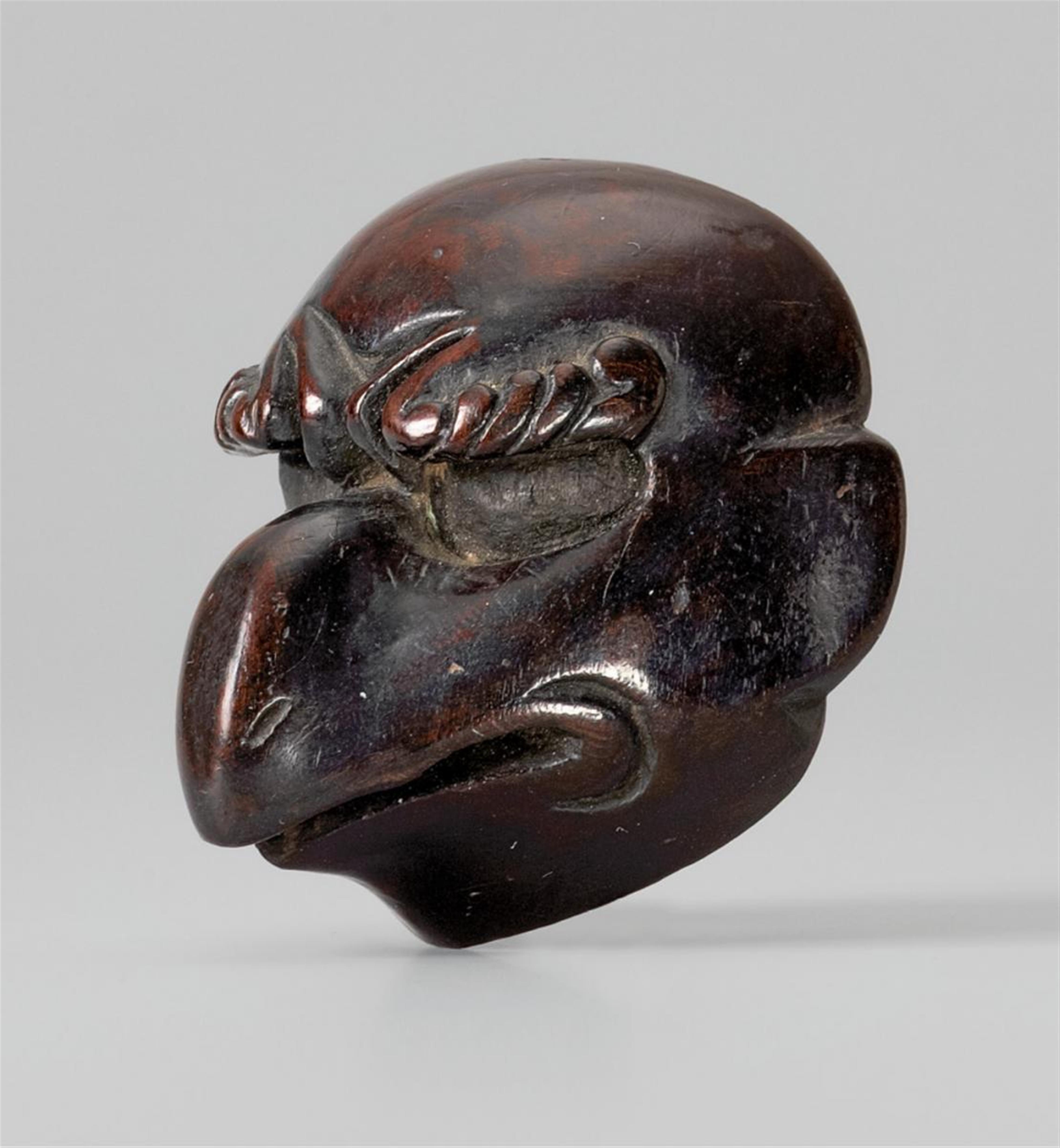 A thinly lacquered wood netsuke of a karasu-tengu head. 18th/19th century - image-1