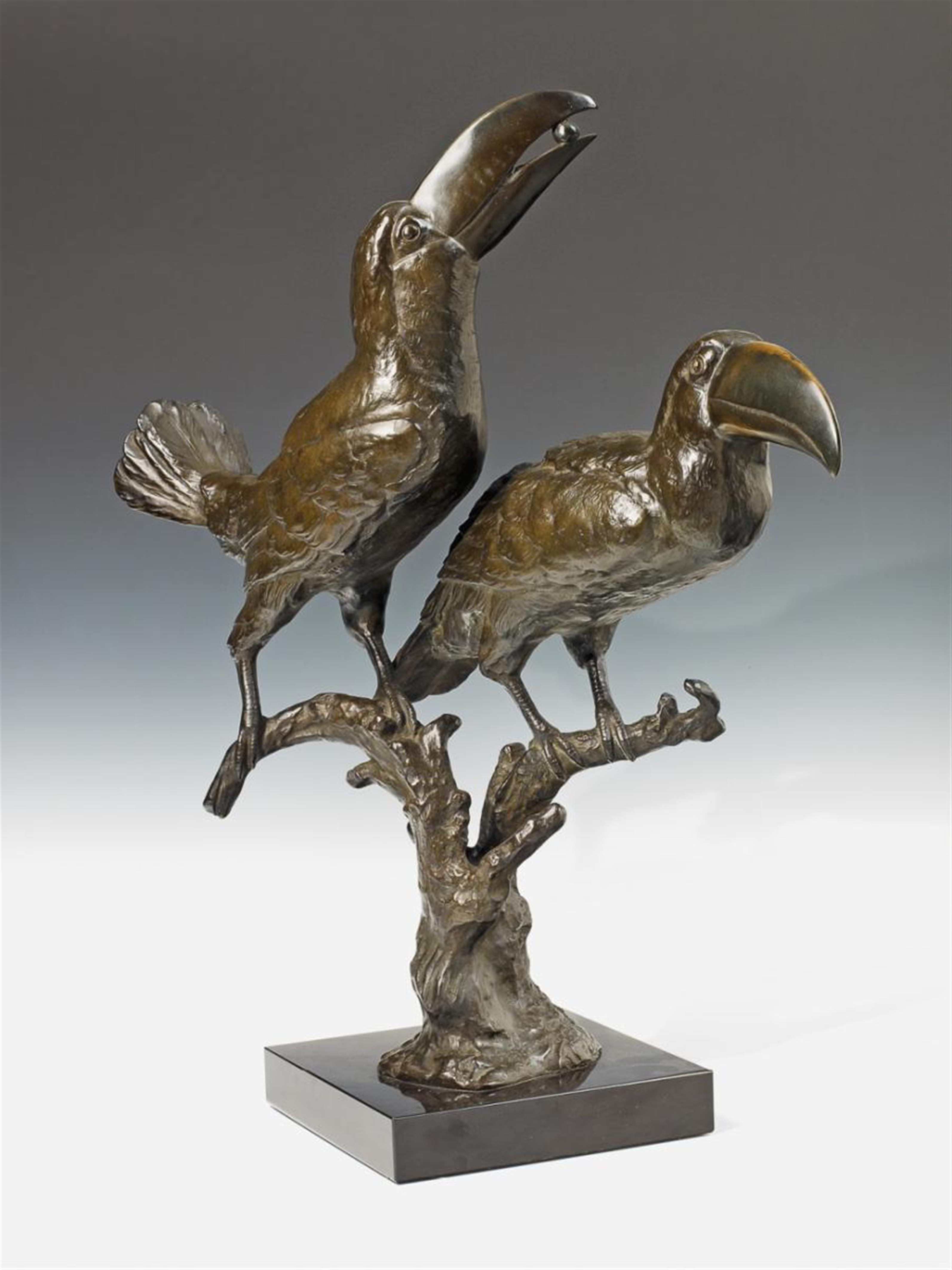 A dark patinated bronze statue of two toucans on a black marble base. - image-1