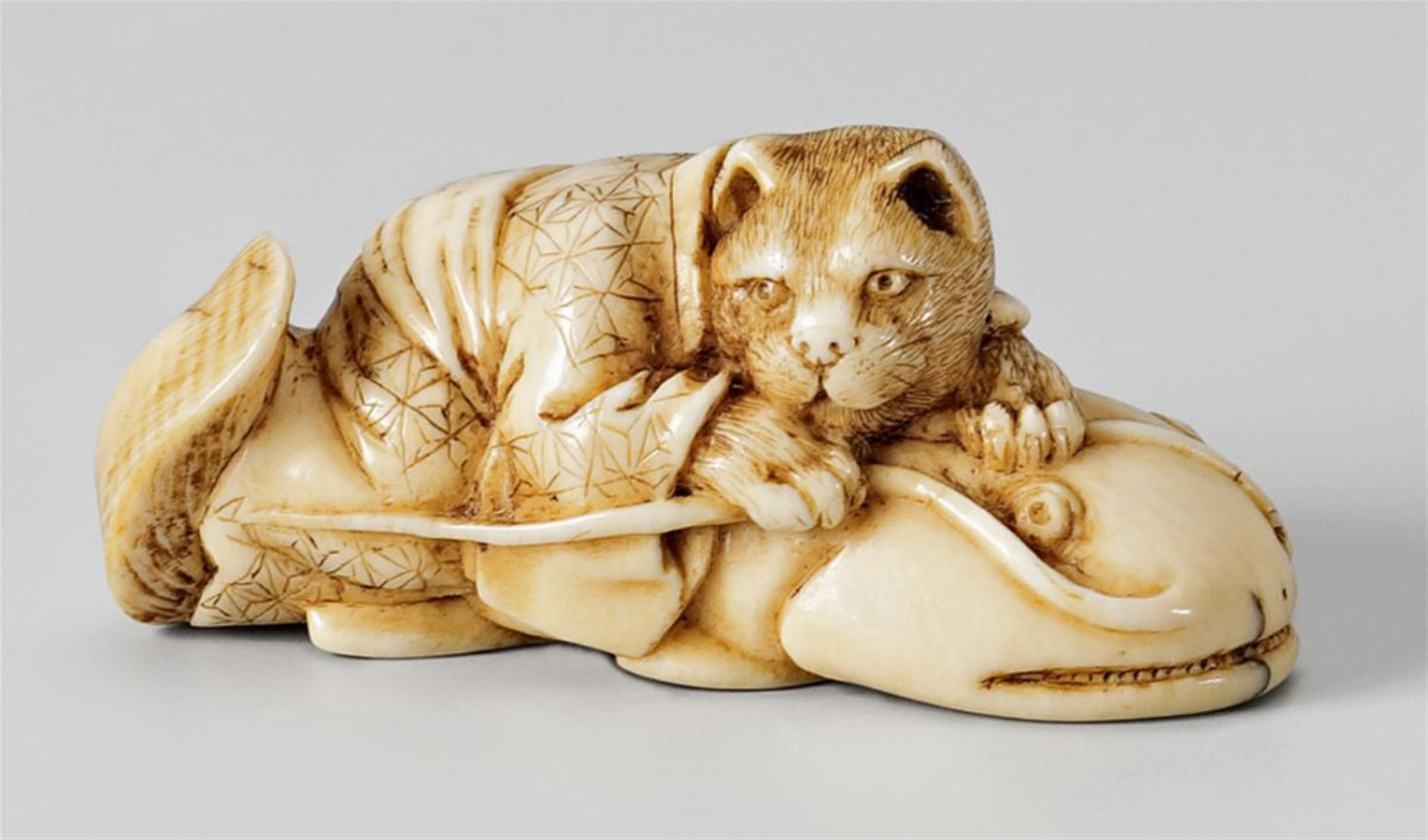 An ivory netsuke of a spotted cat on a namazu. Late 19th century - image-1