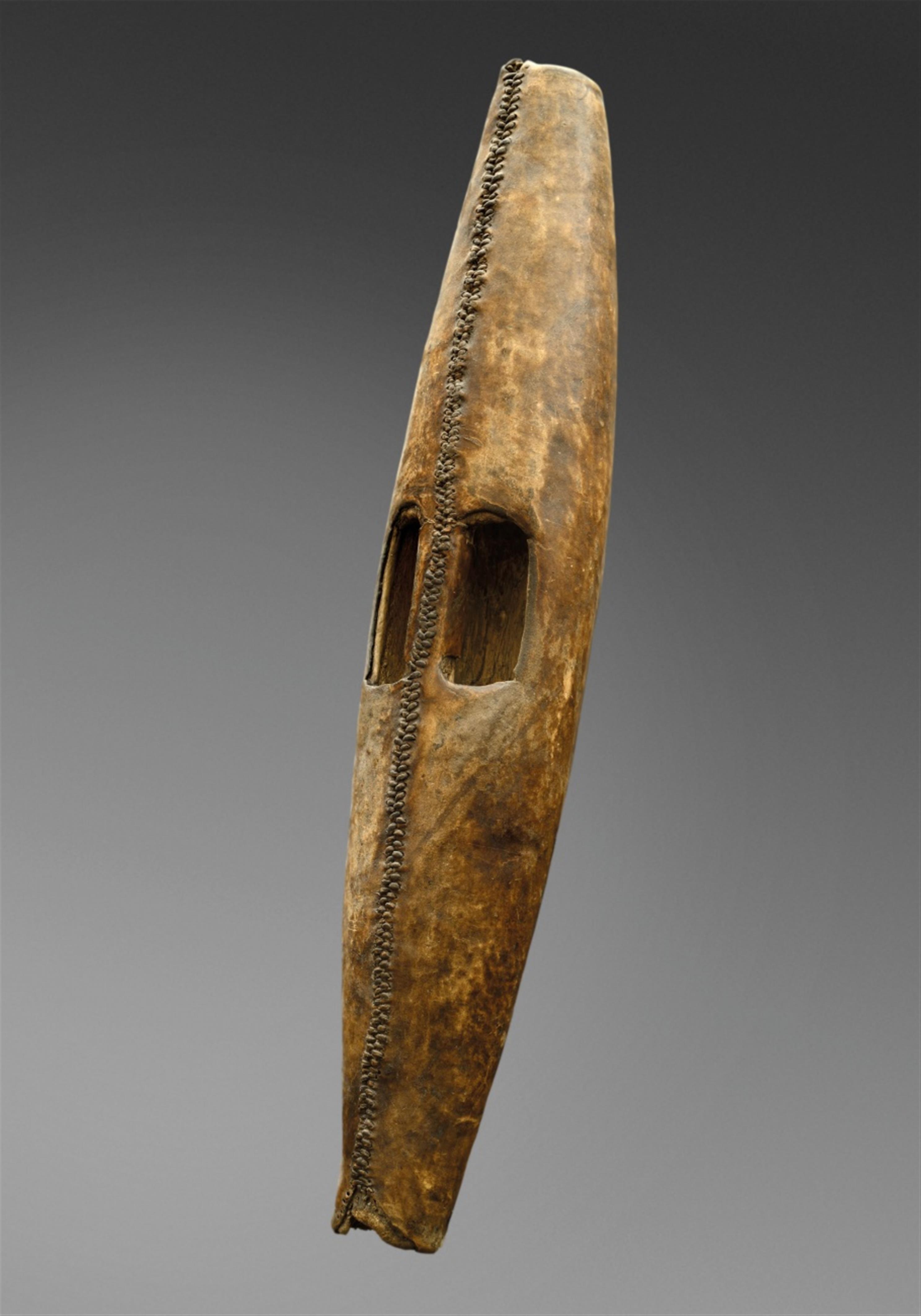 TWO SUDAN SHIELDS A Shilluk shield of cylindrical form tapering at each end, covered in hide, carved grip; and a Dinka shield, of ovoid form with carved grip, dark patina. - image-1