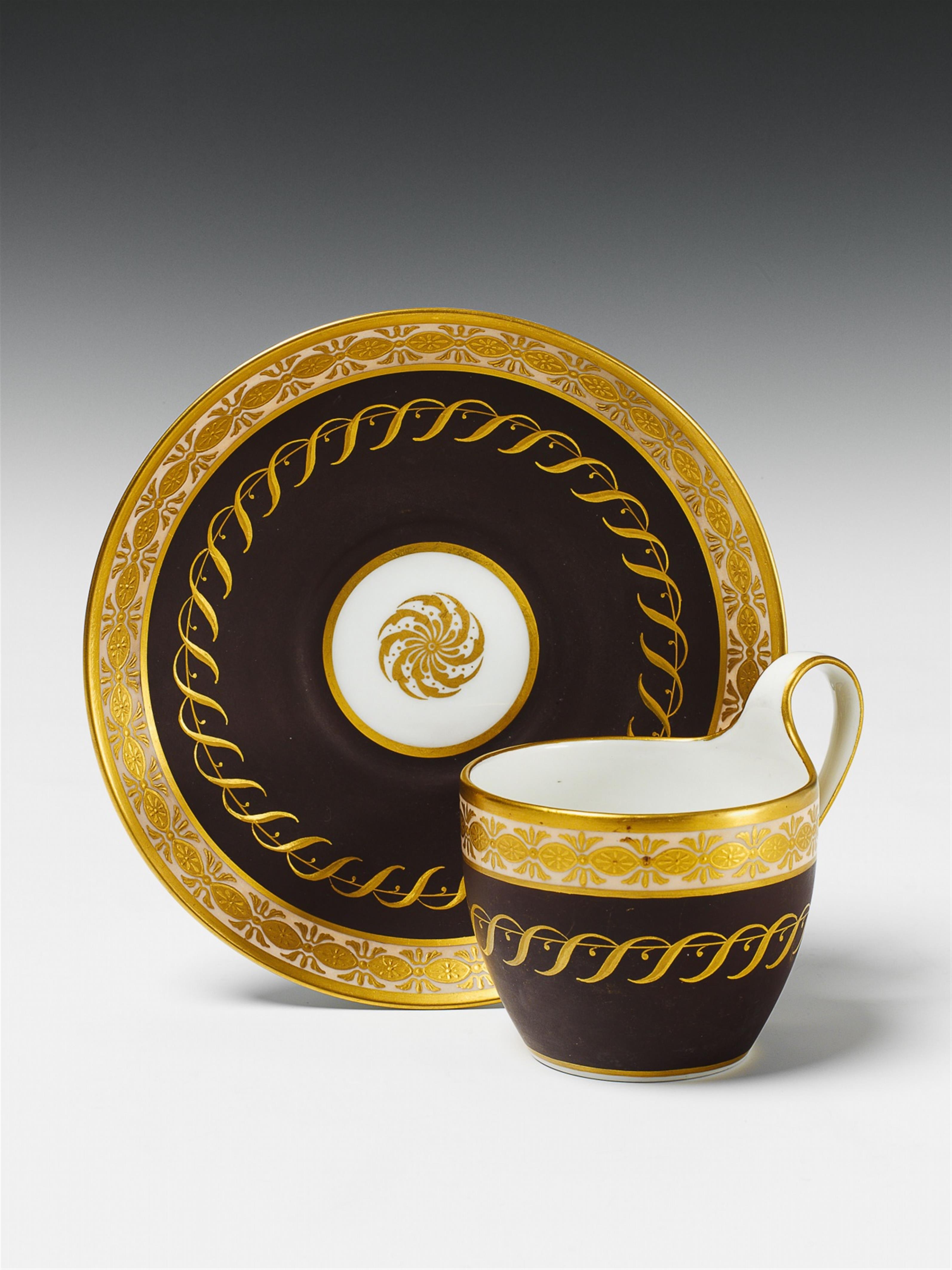 A Berlin KPM porcelain cup with gilt scroll decor on a brown ground. - image-1