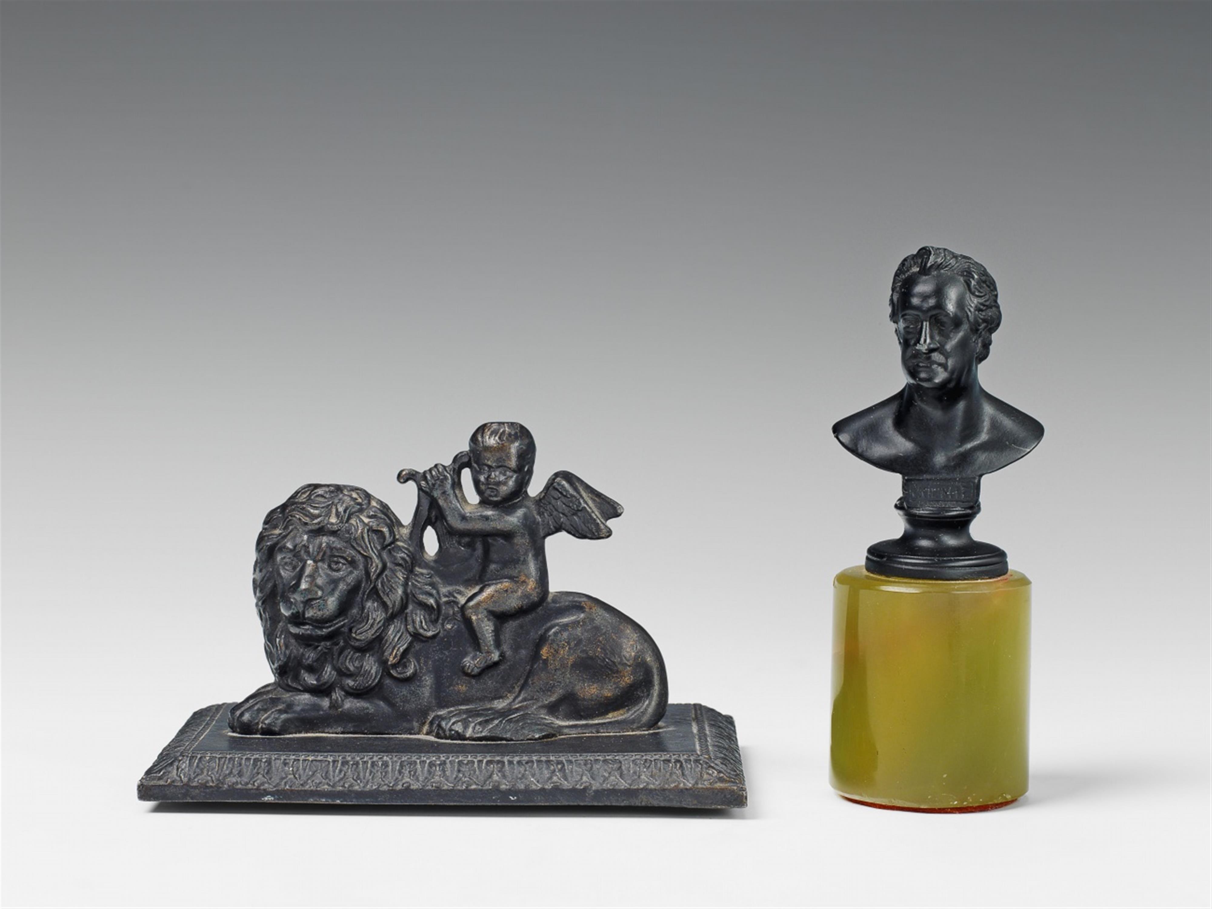 A Prussian cast iron paperweight formed as Cupid riding a lion. - image-1
