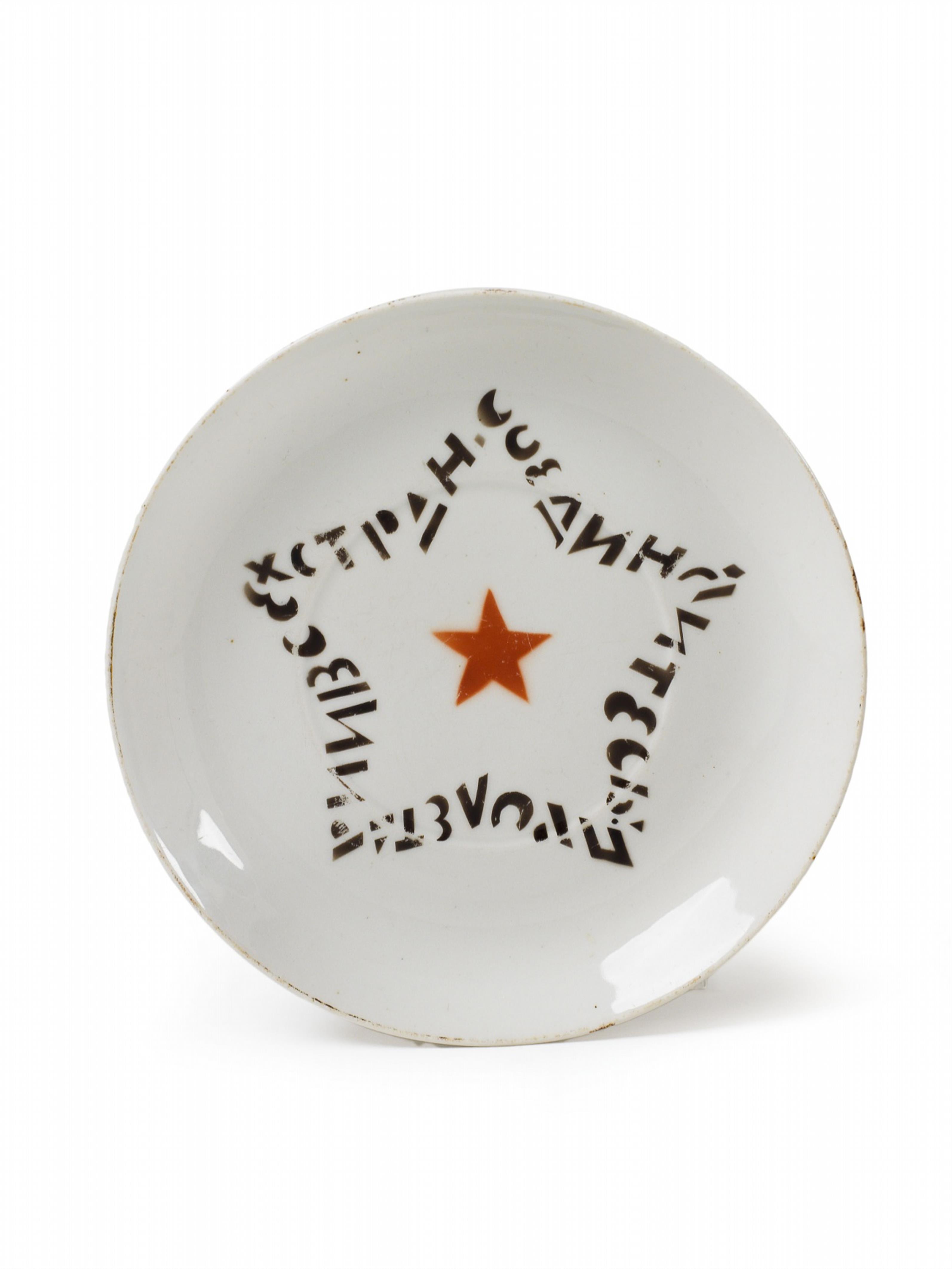 A slightly scalloped round porcelain dish with stencilled and painted decor, inscribed "Proletariat of all nations unite". - image-1