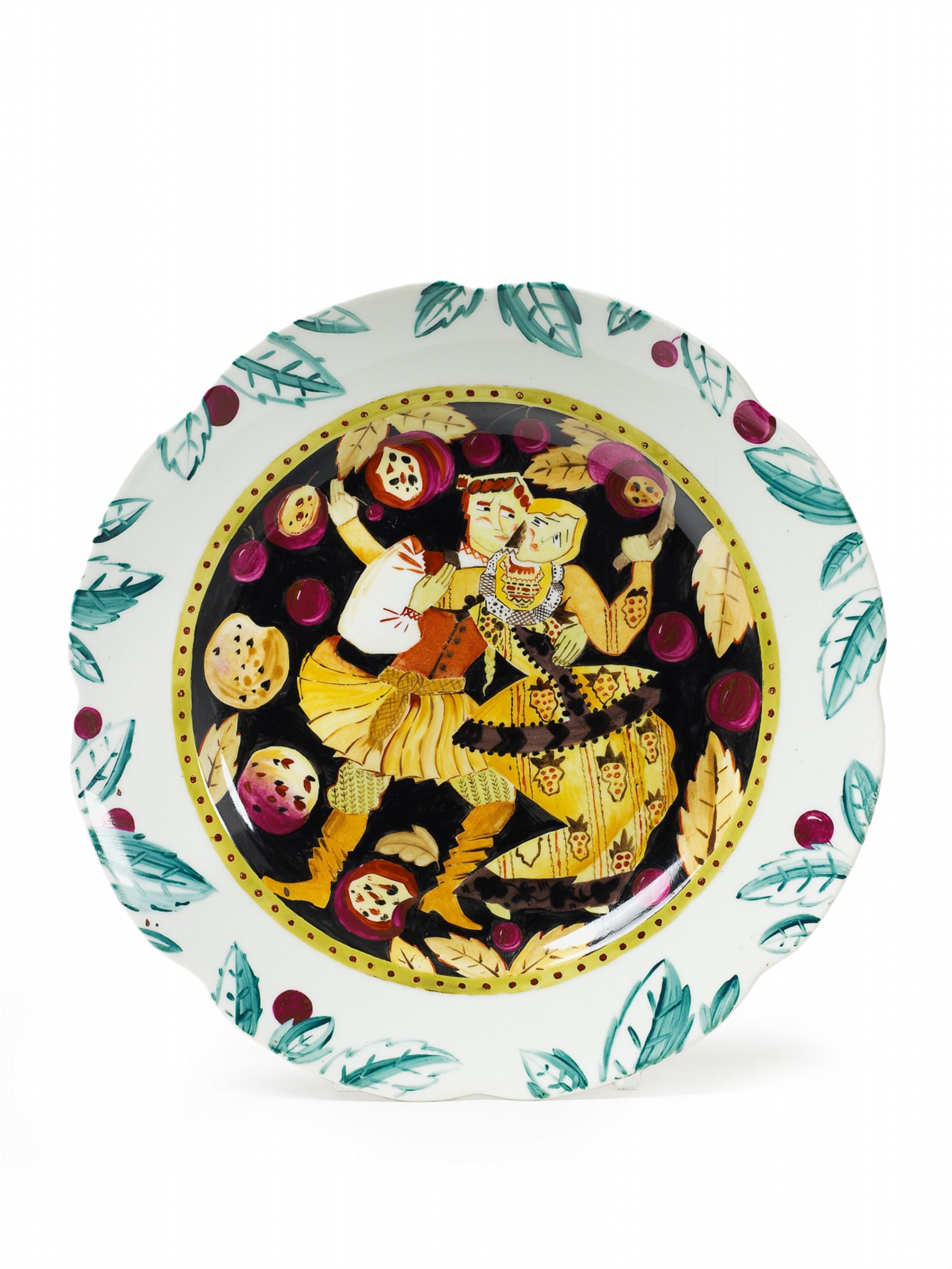 A shaped porcelain plate with an enamel depiction of a peasant couple dancing amid falling fruit. - image-1