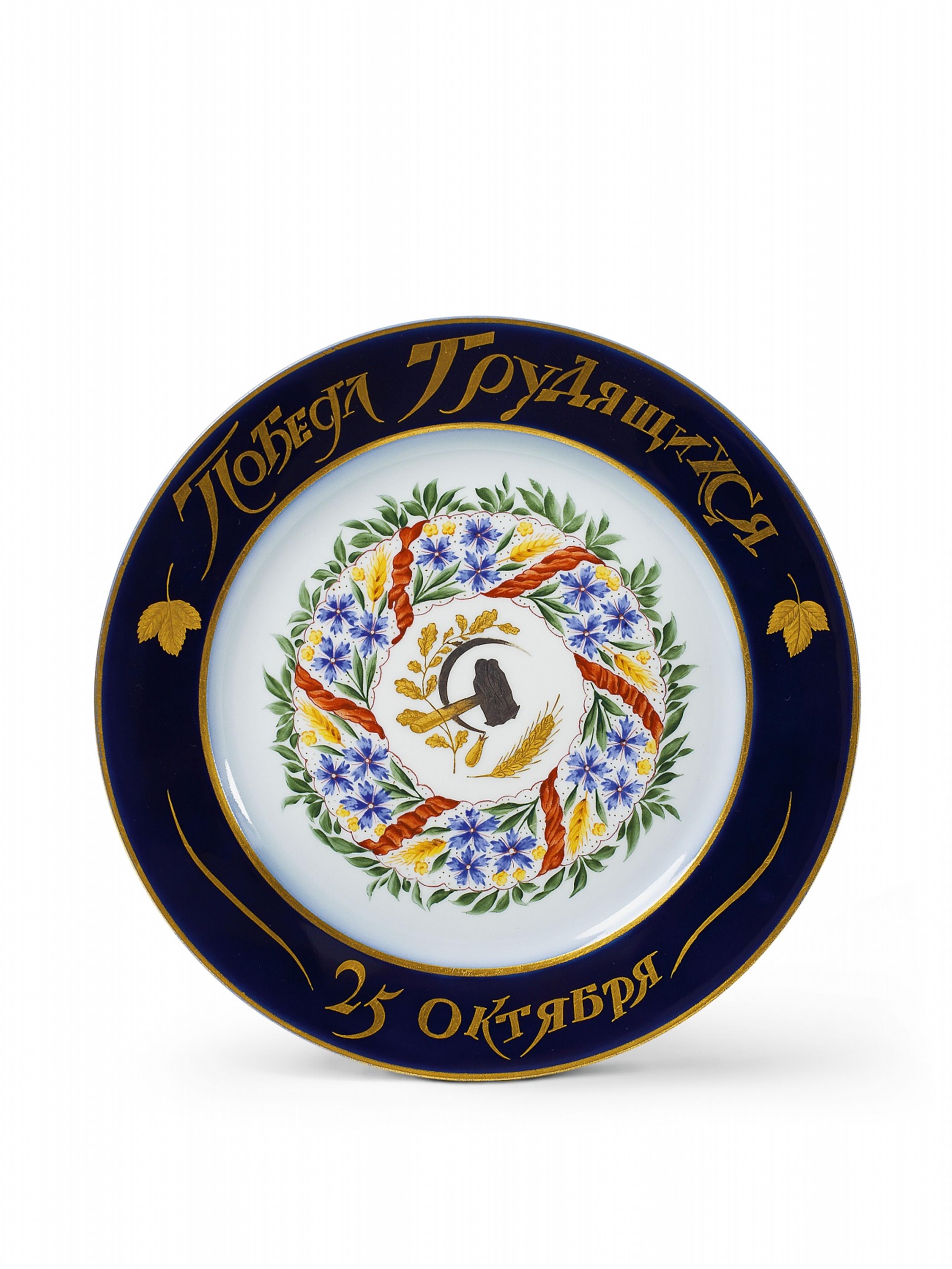 A porcelain plate centrally decorated with a wreath commemorating the October Revolution, inscribed "Triumph of the labourers 25th October". - image-1