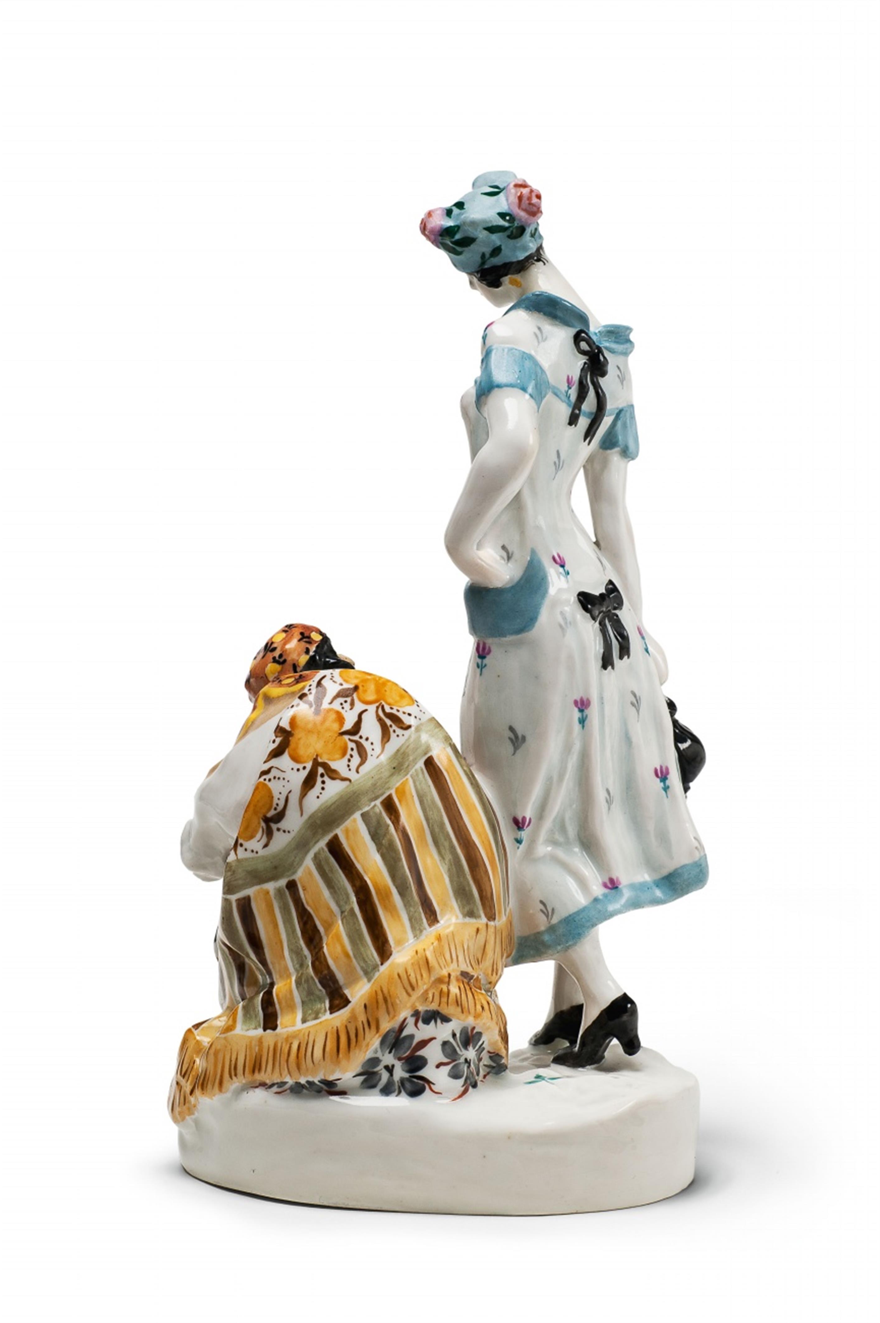 A porcelain group of a fashionably dressed young lady and a crouching fortune teller. - image-3
