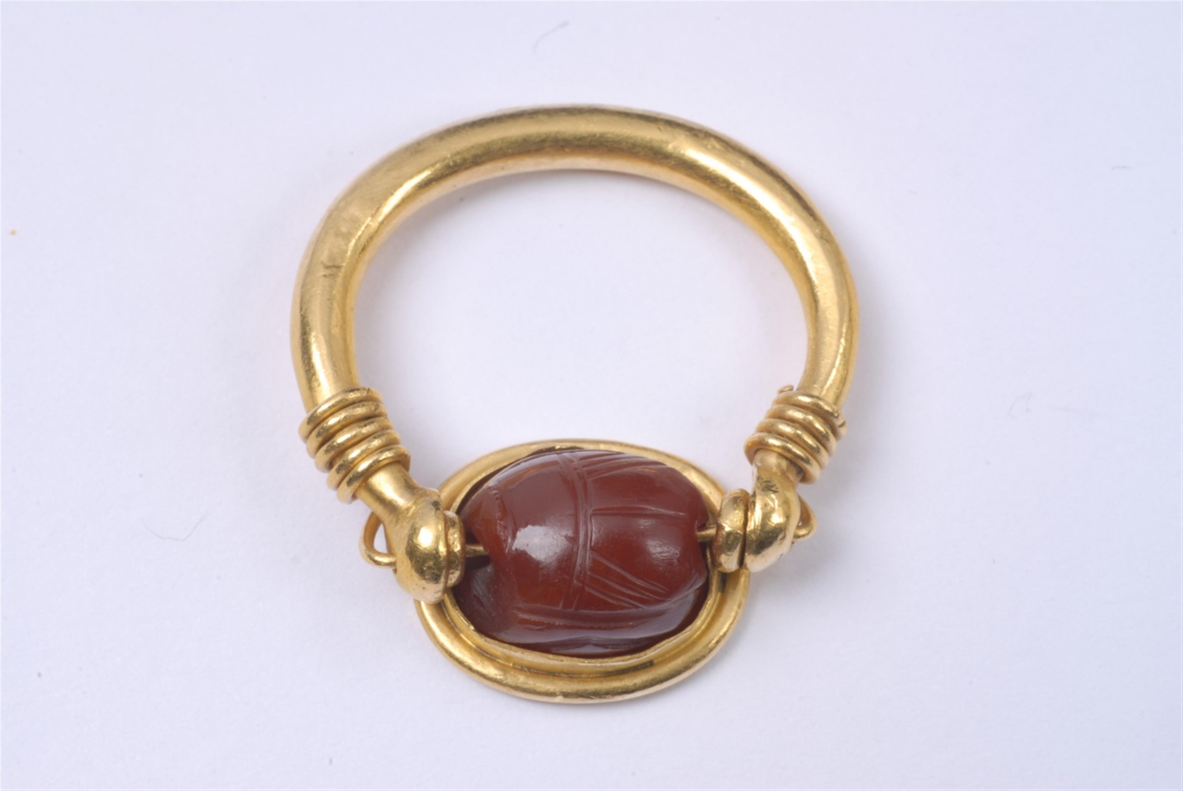 A gold ring with a Etruscan scarab intaglio. - image-1