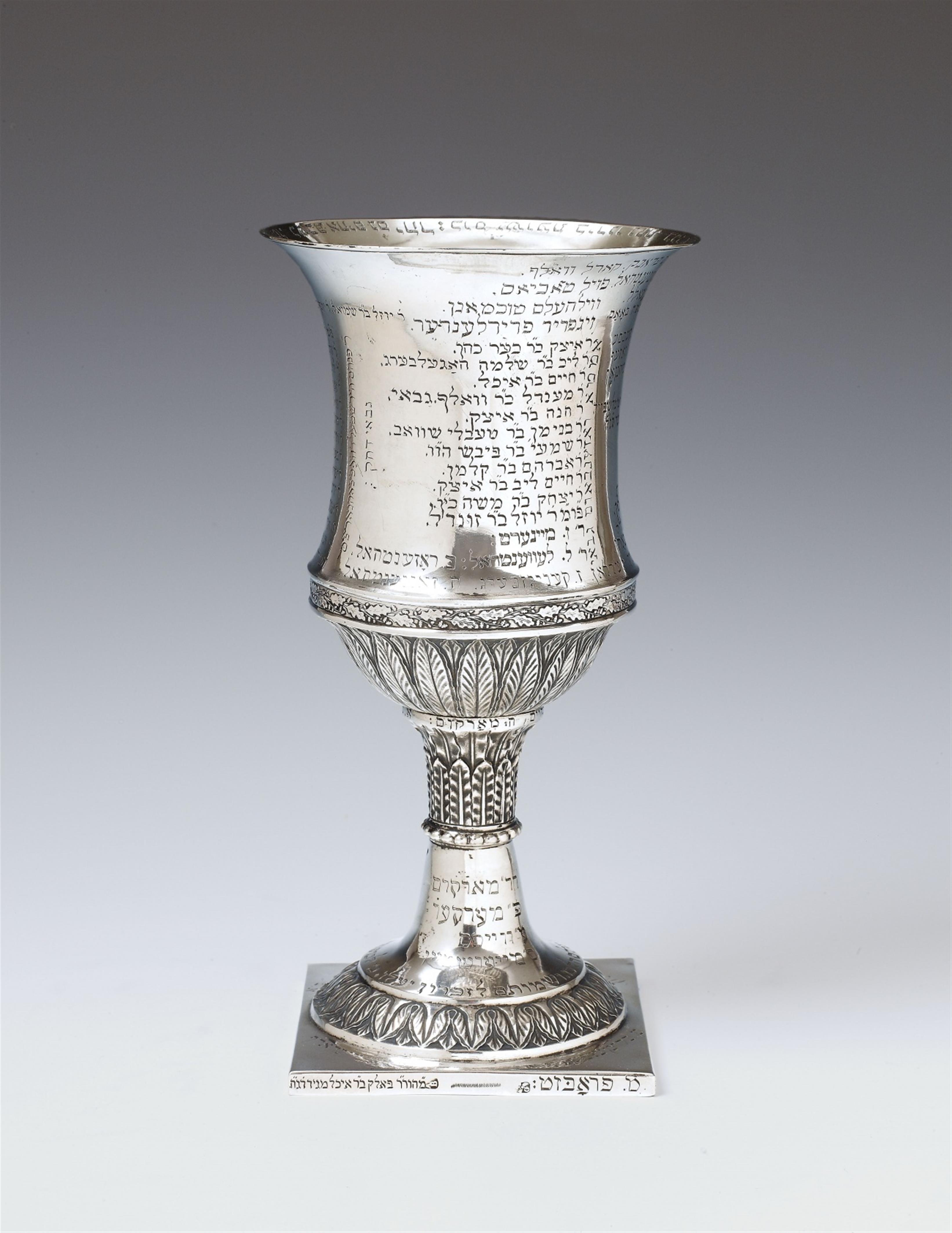 An important Saxon silver cup of a Jewish fraternity. The round foot resting on a square plinth and supporting a waisted shaft with palmette decor, the vase form cup correspondingly decorated. With extensive engraved Hebrew inscriptions throughout. Saxony - image-1
