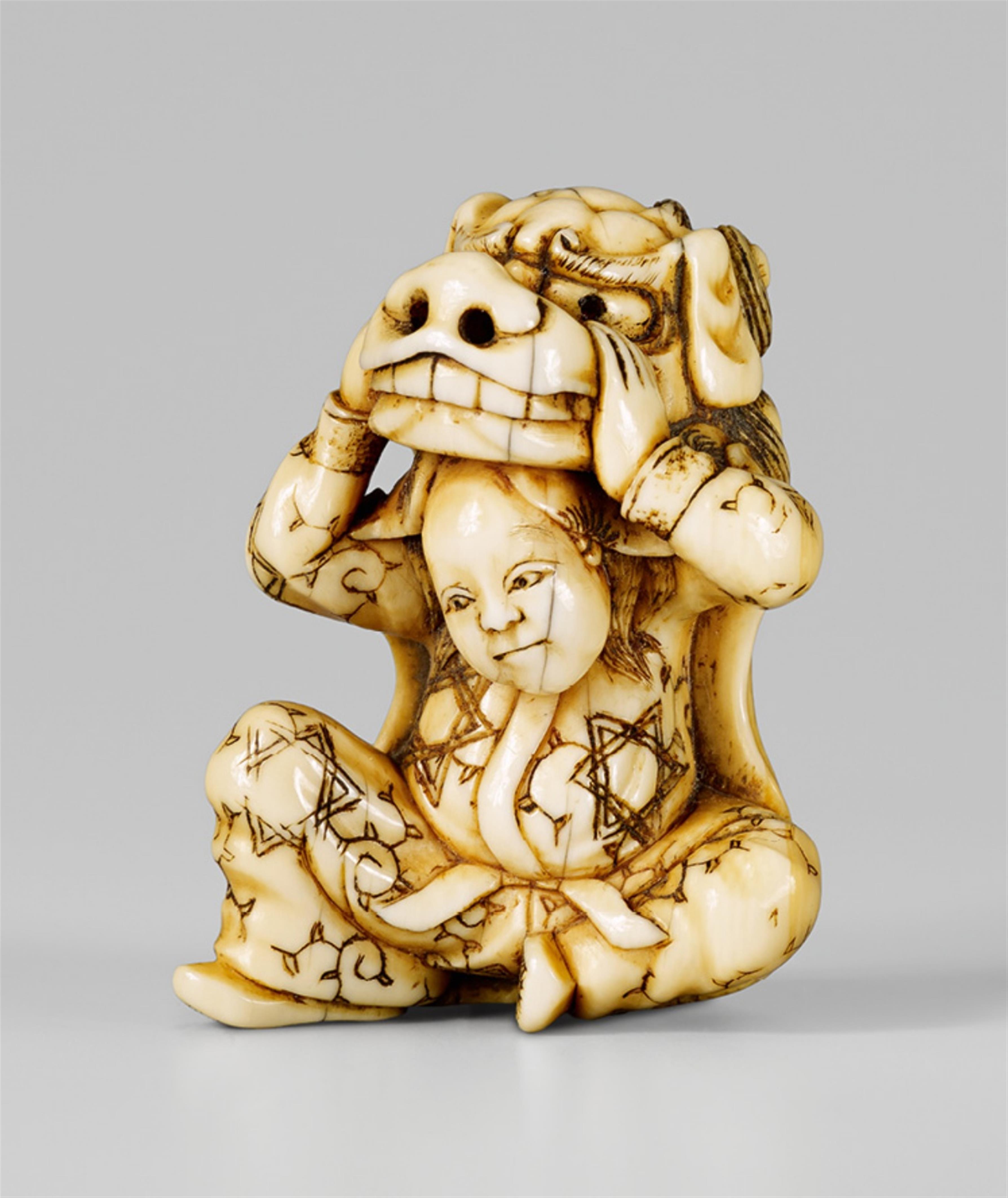 A good, partly stained ivory netsuke of a seated shishi dancer. Early 19th century - image-1