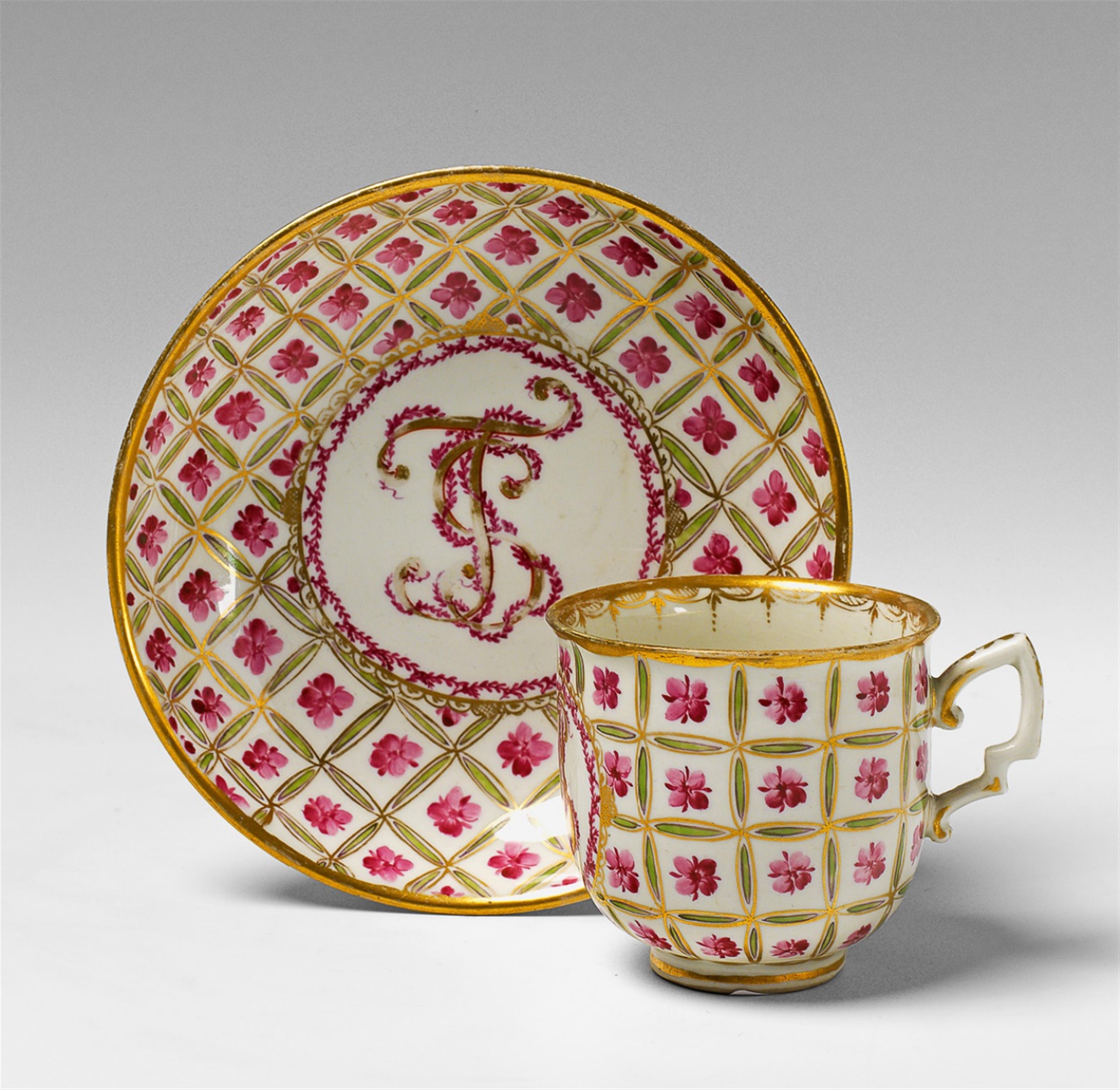 A Vienna porcelain teacup and saucer with floral trellis decor. - image-1