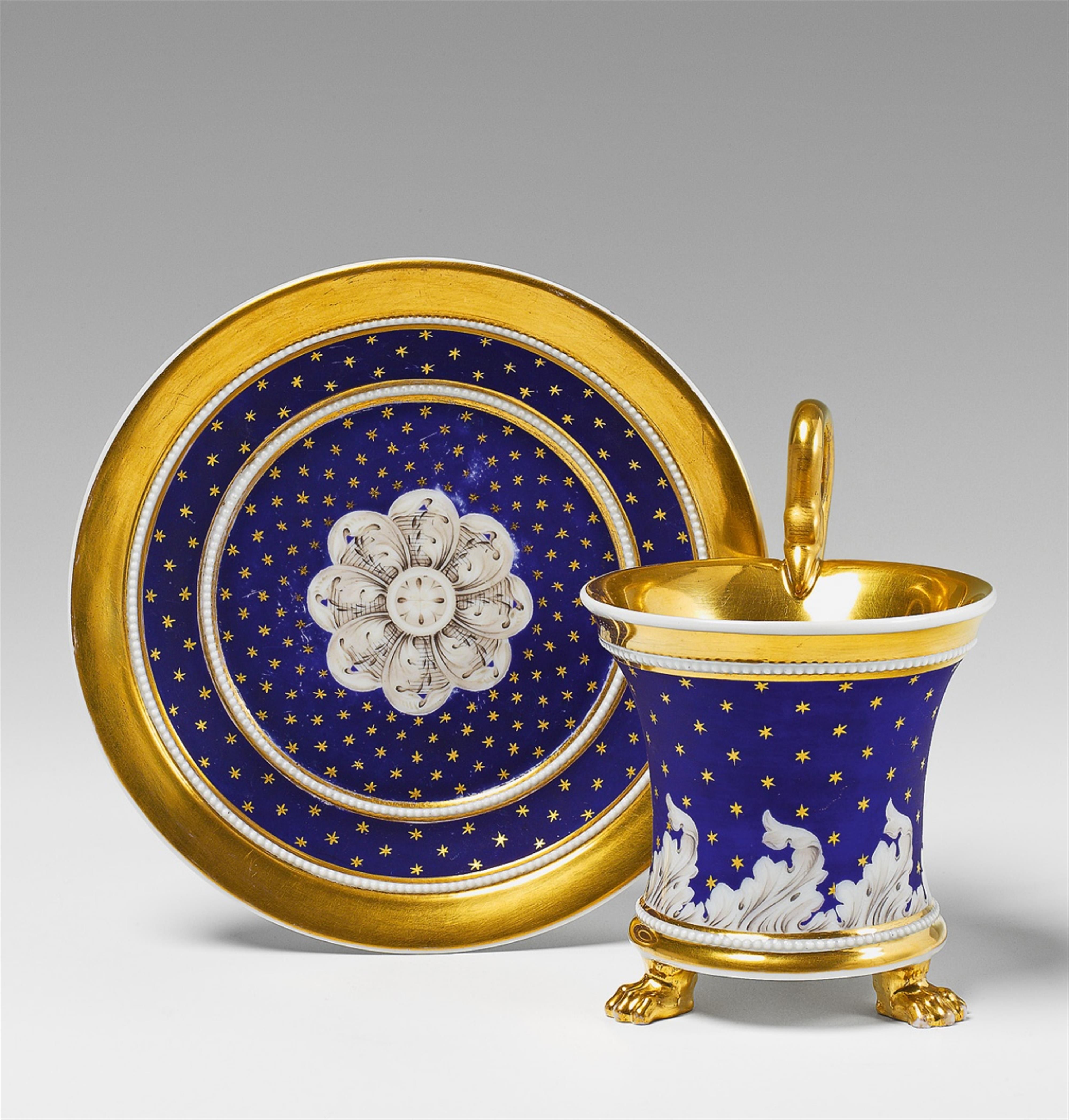 A Berlin KPM cup and saucer with star decor on blue ground. - image-1