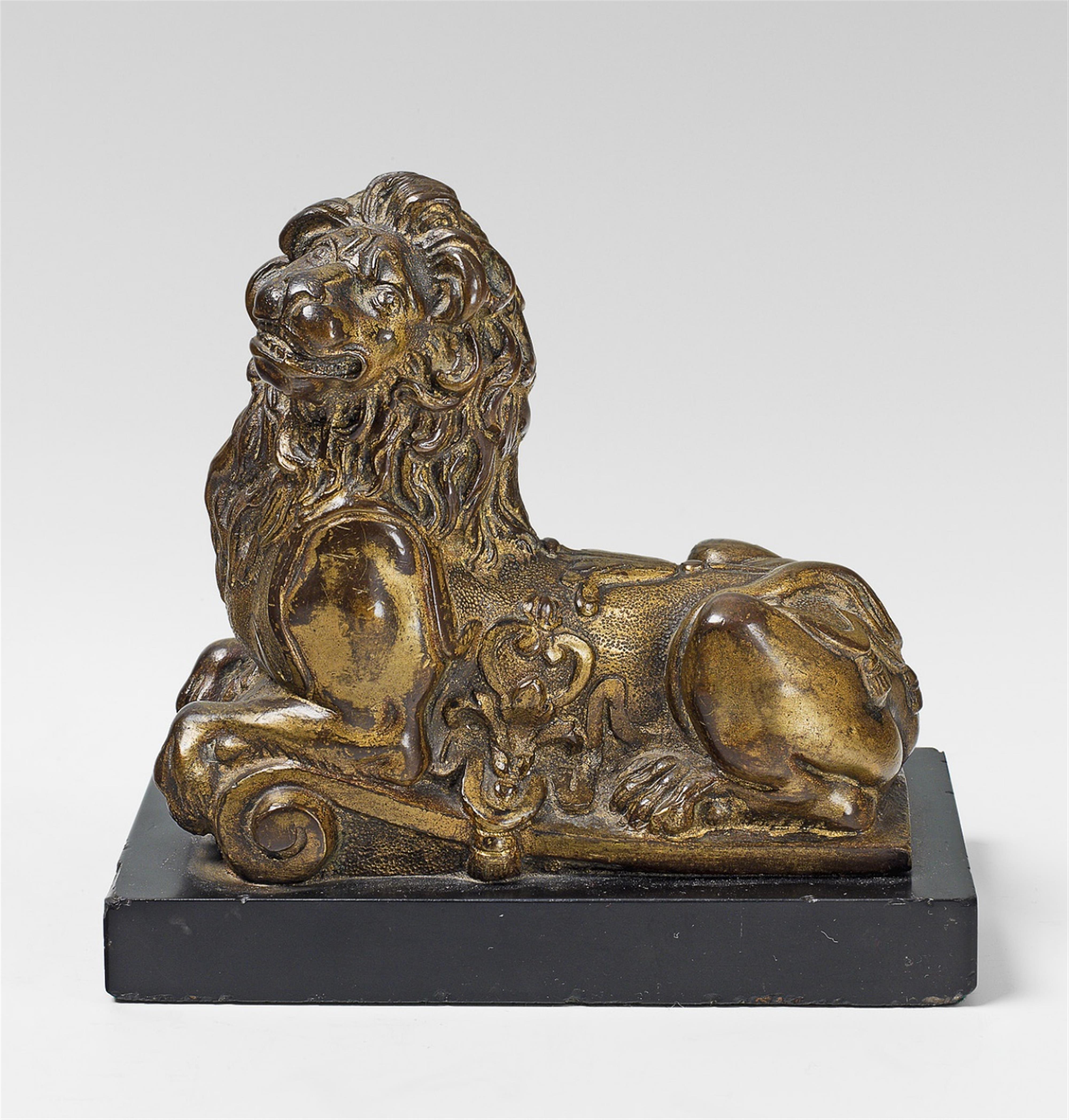 A small, Régence bronze model of a lion on a marble plinth. - image-1