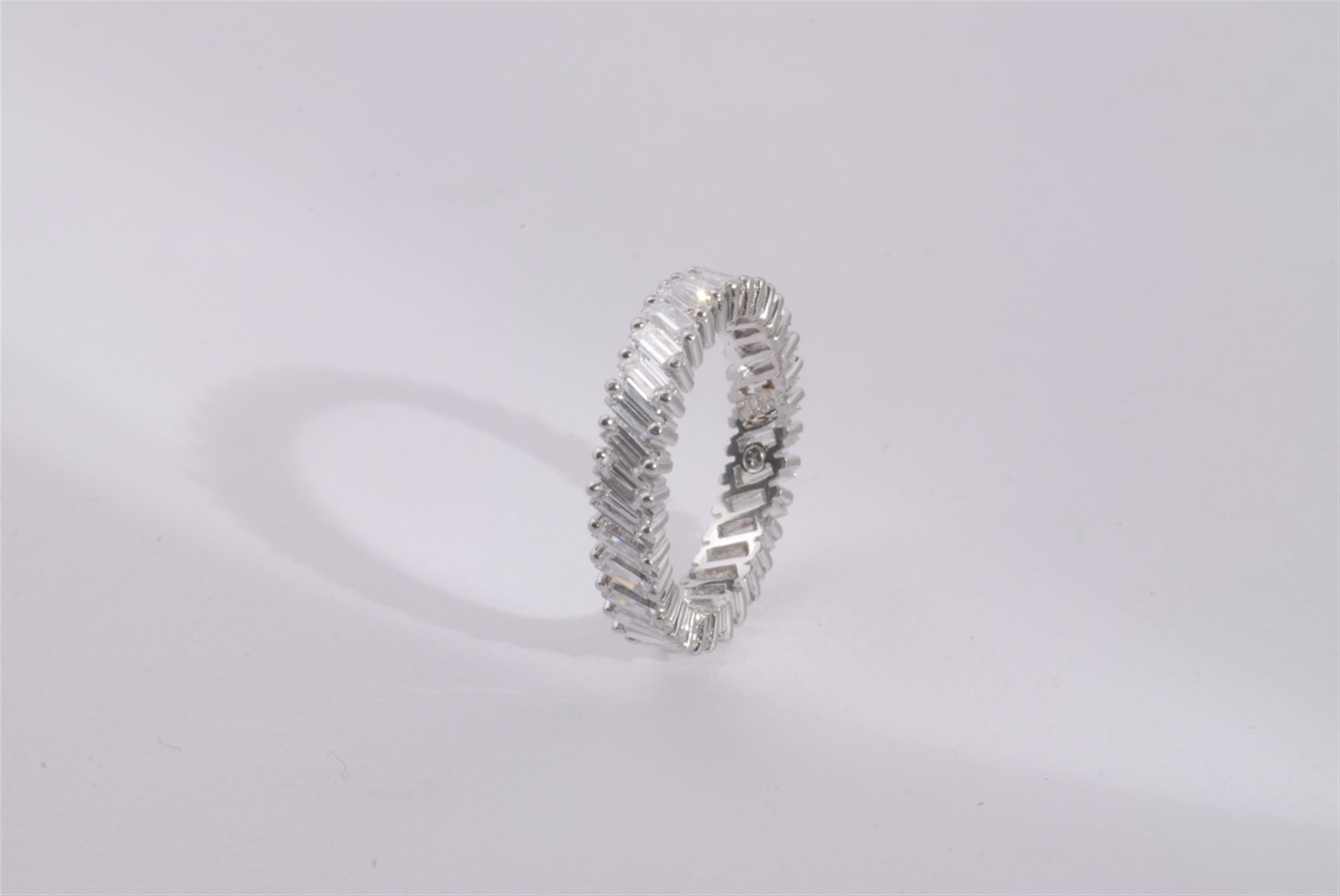 A platinum and diamond eternity ring. - image-1