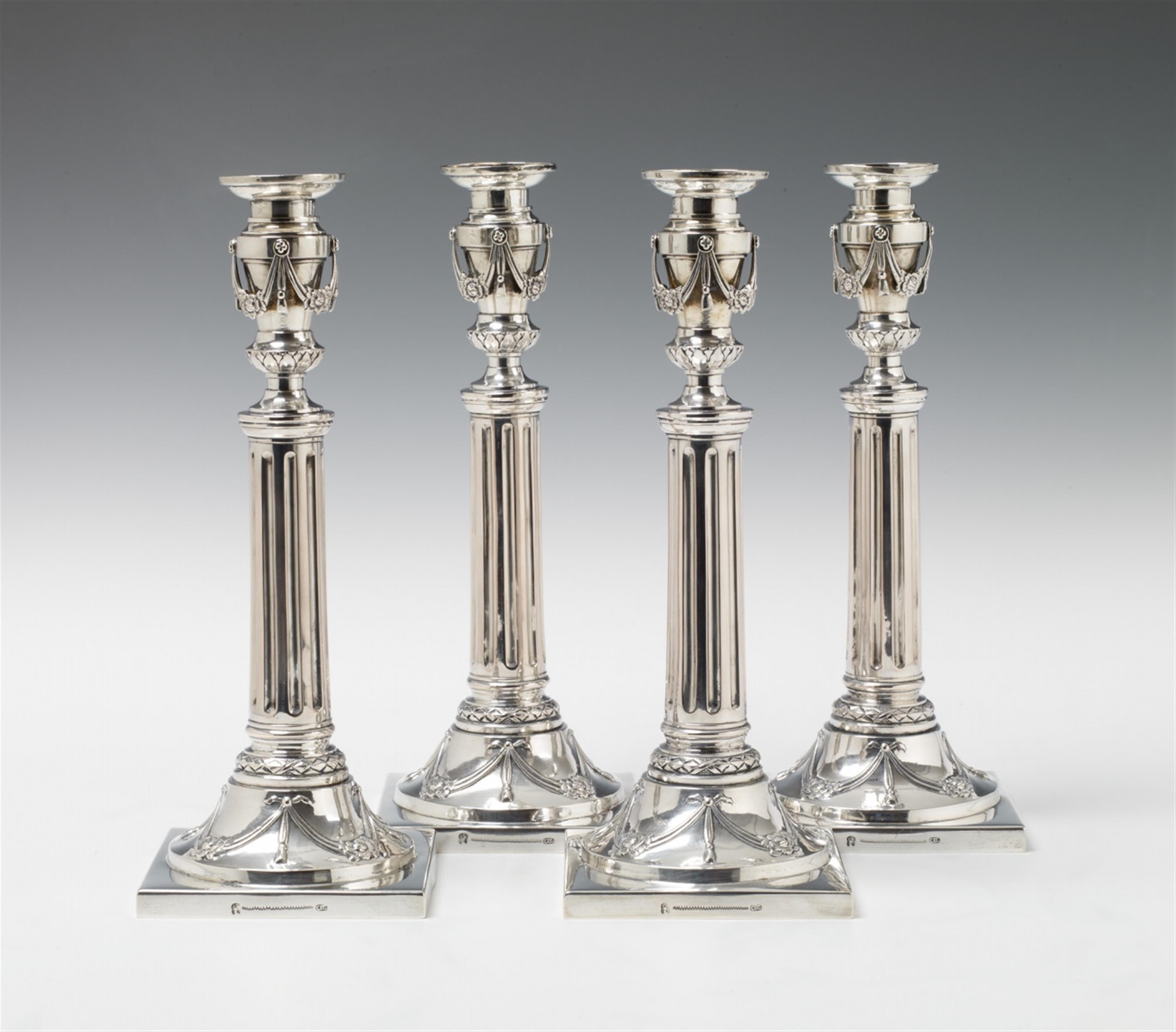 A set of four silver candlesticks - image-1