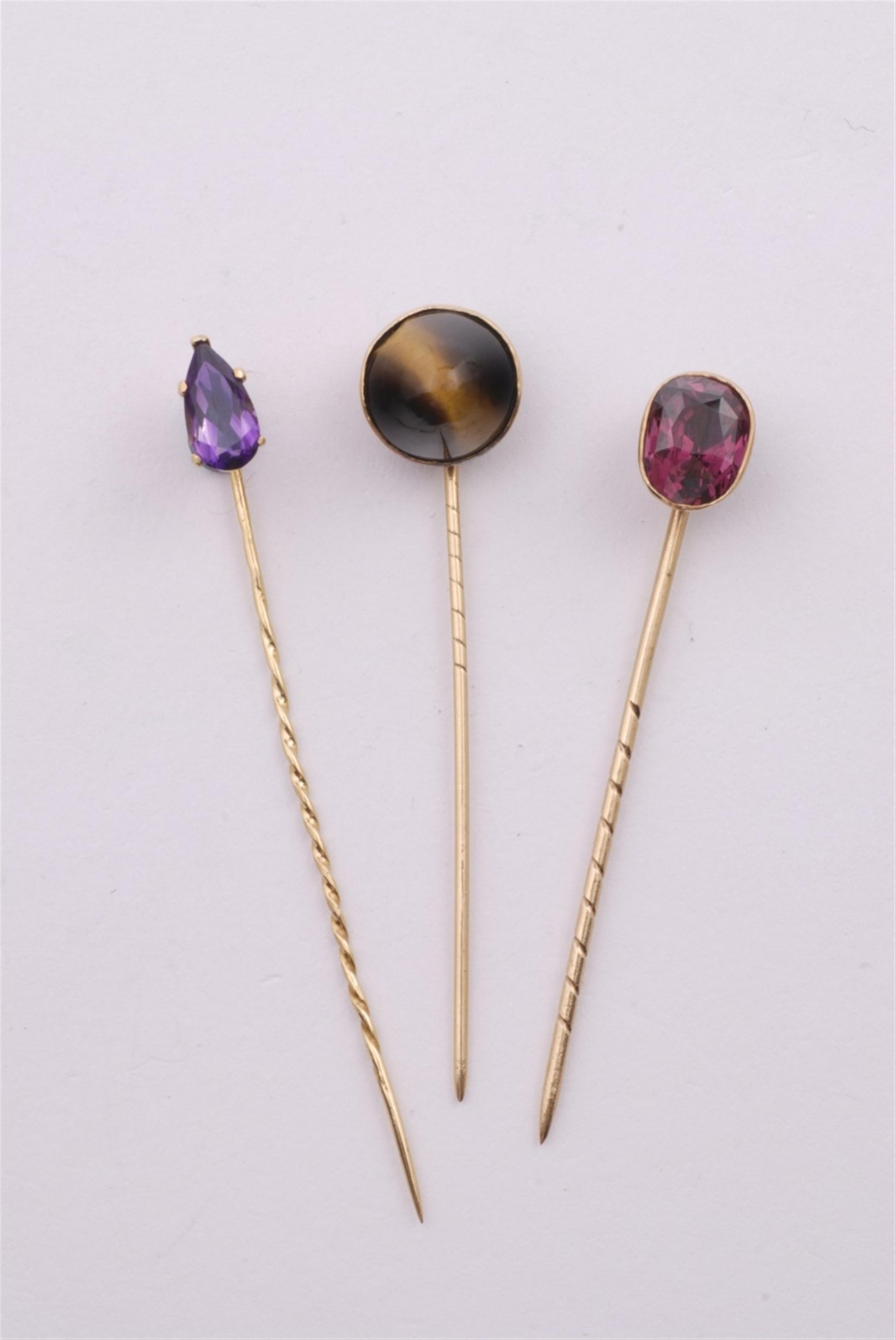 Three 18- and 14k gold tie pins with coloured stones. - image-1