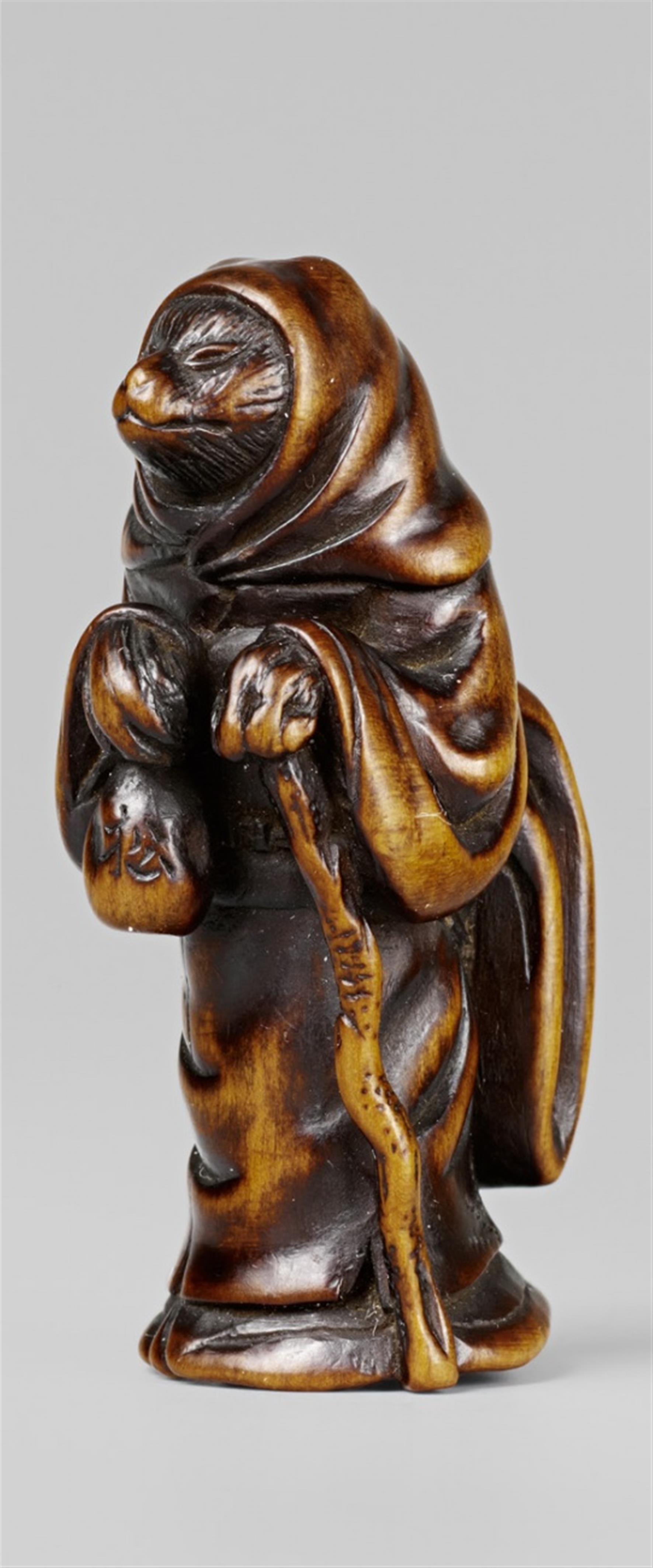 A boxwood netsuke of the fox or tanuki dressed as a woman. First half 19th century - image-1
