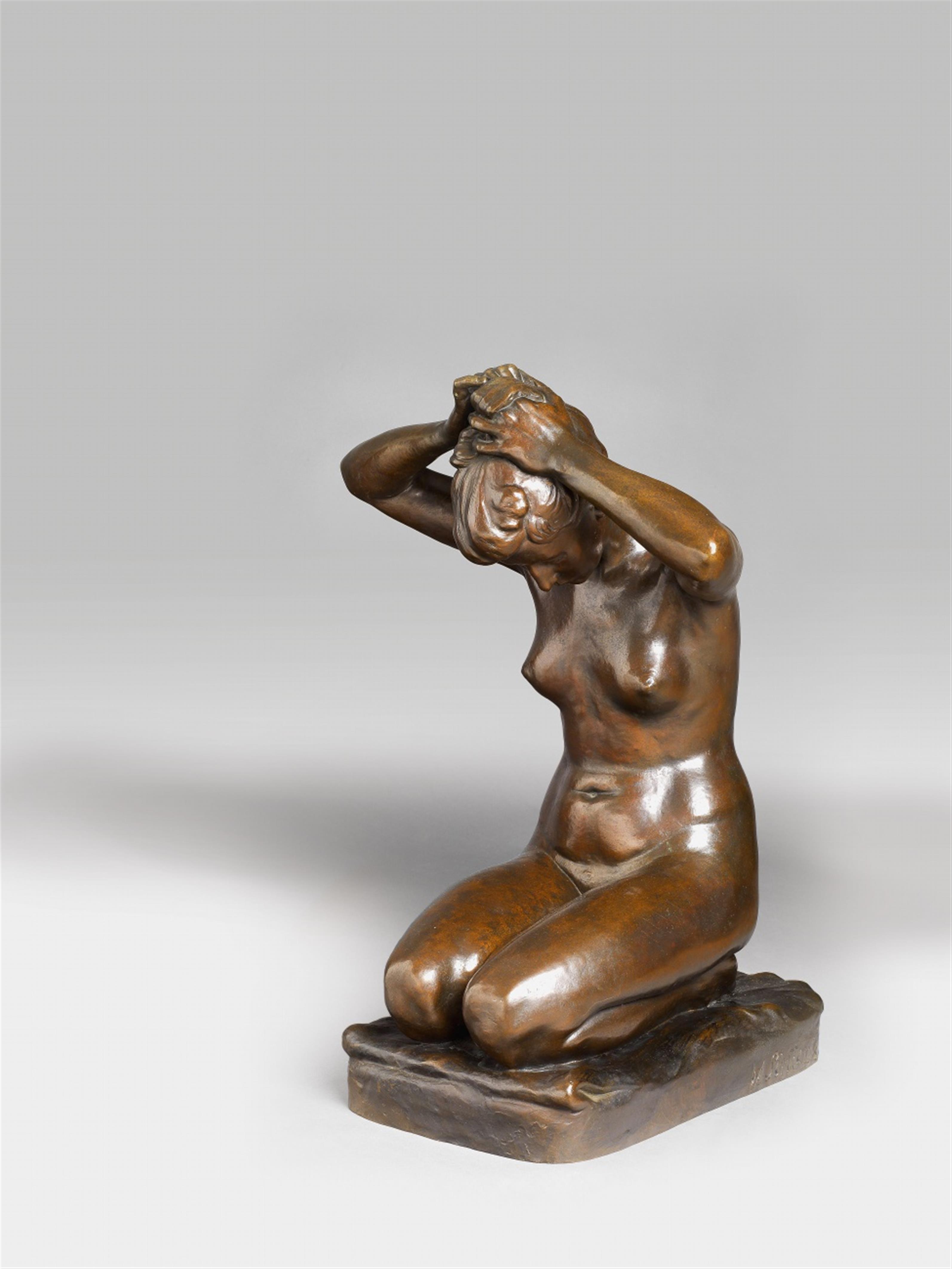 A bronze sculpture of a girl tying her hair - image-1
