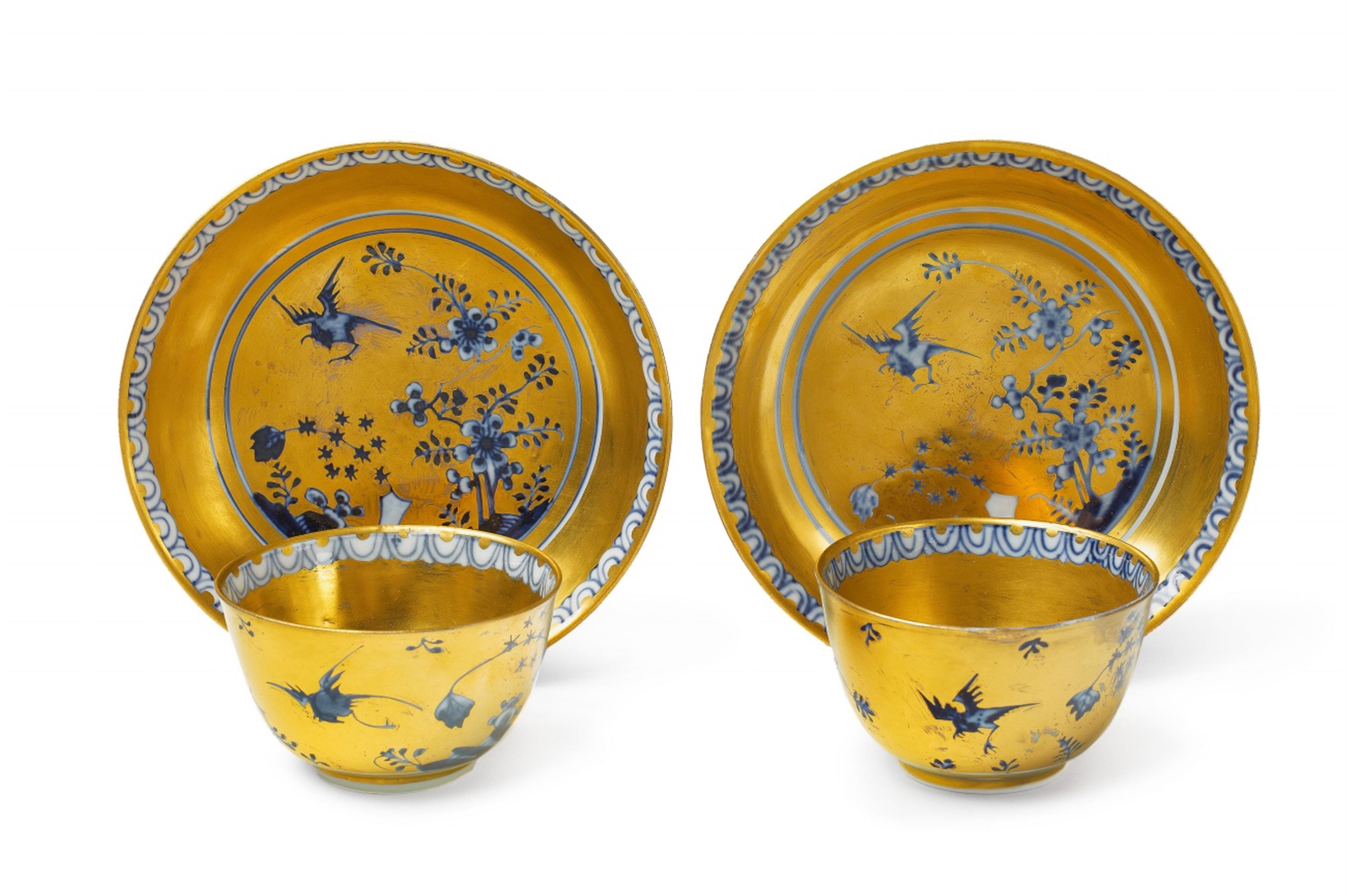 A pair of Meissen porcelain tea bowls with gold overpainted rock and bird decor - image-1