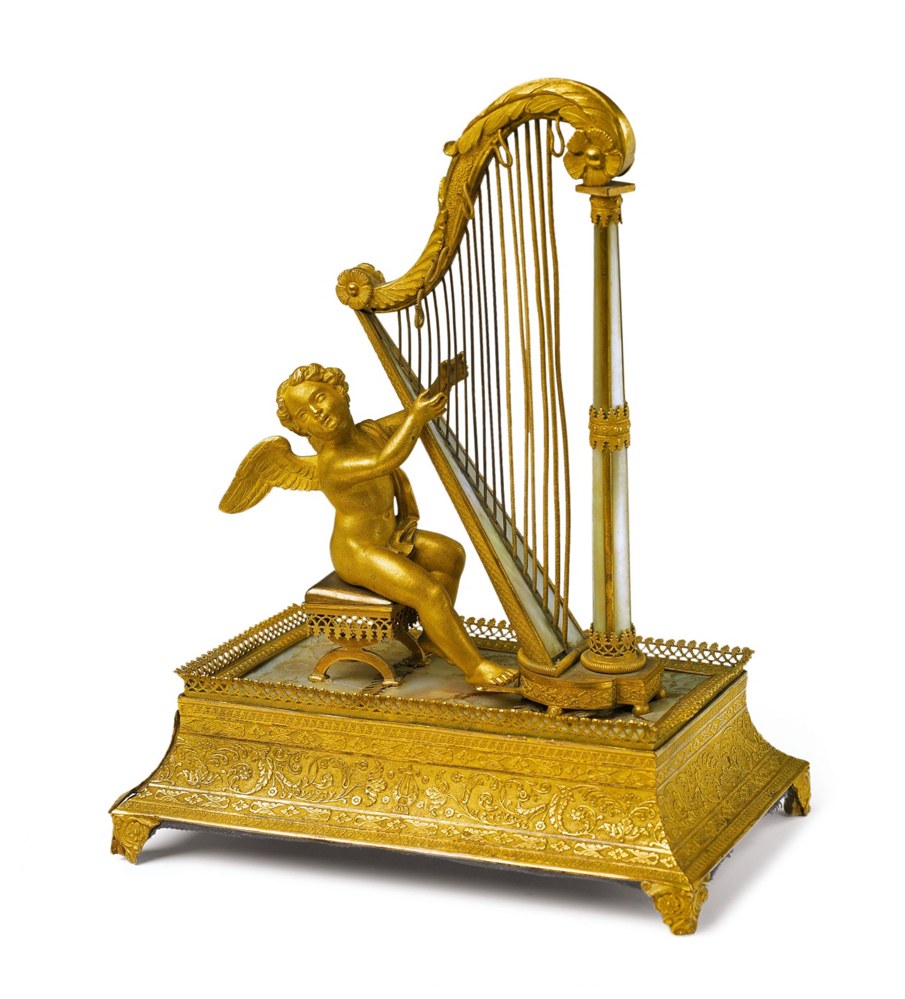 A fire-gilt bronze musical box formed as a putti playing a harp - image-1