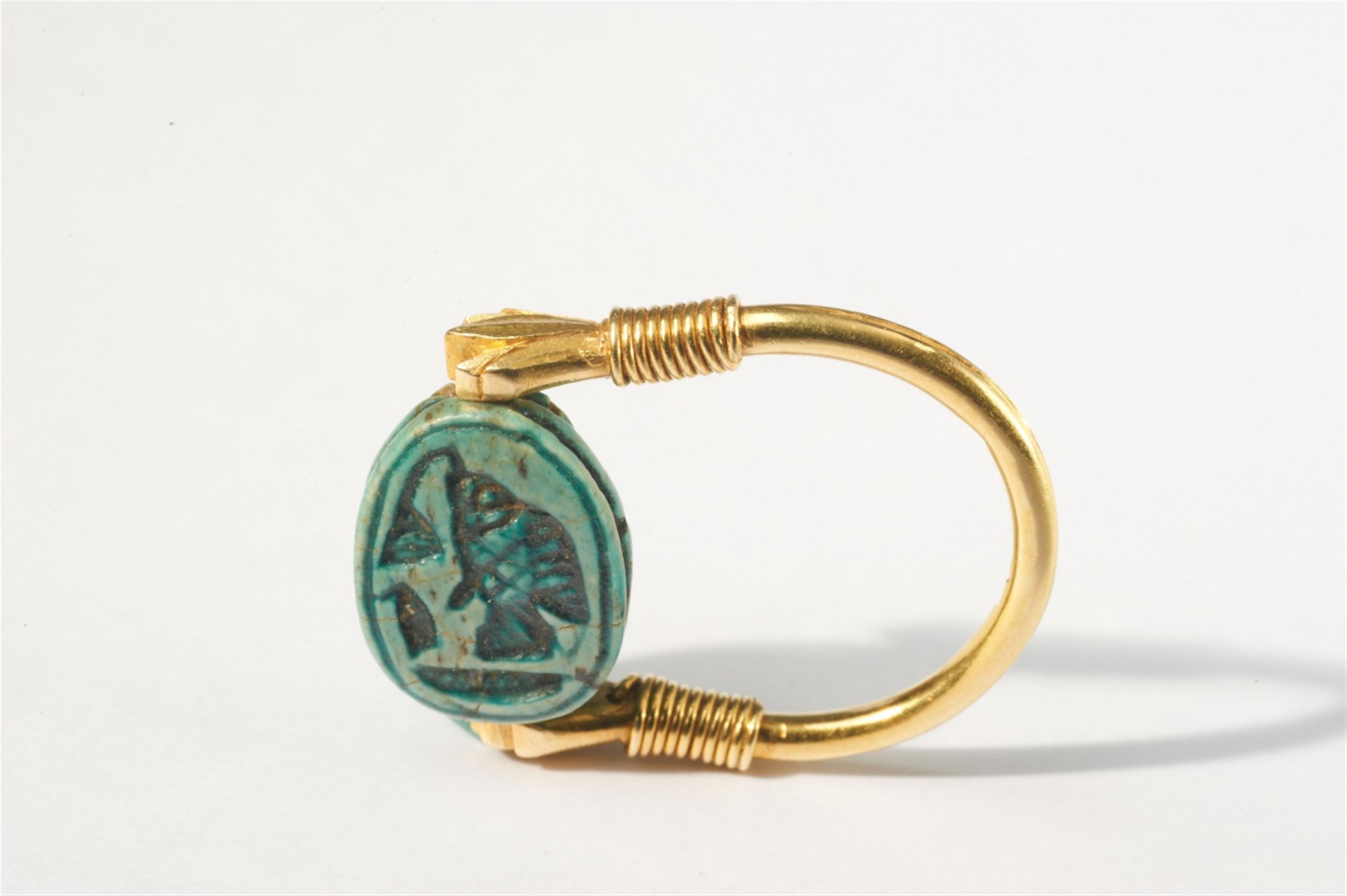 An 18k gold swivel ring with a glazed faience scarab - image-1