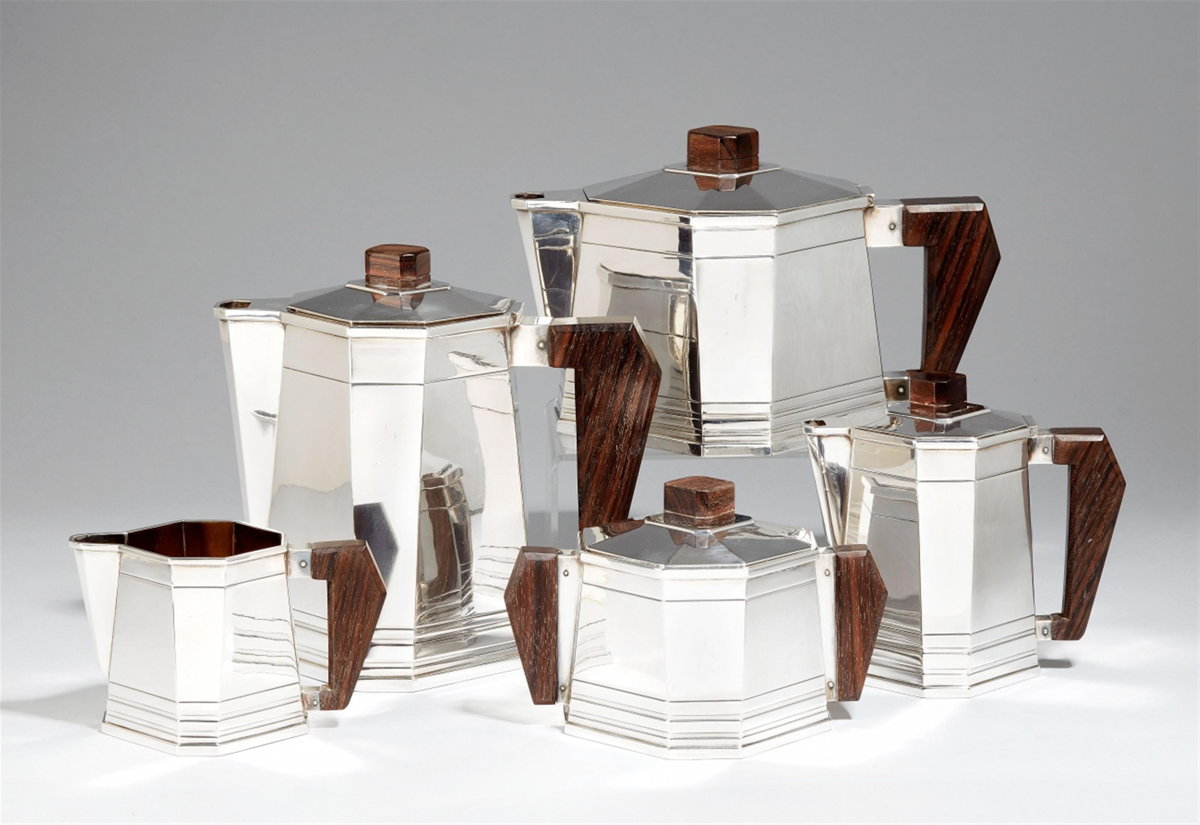 A Parisian Art Deco silver tea and coffee service. Comprising tea- and coffee pots, milk jug, mocca pot and sugar box. The handles and finials of palisander wood. Marks of Saglier Frères, ca. 1920. - image-1