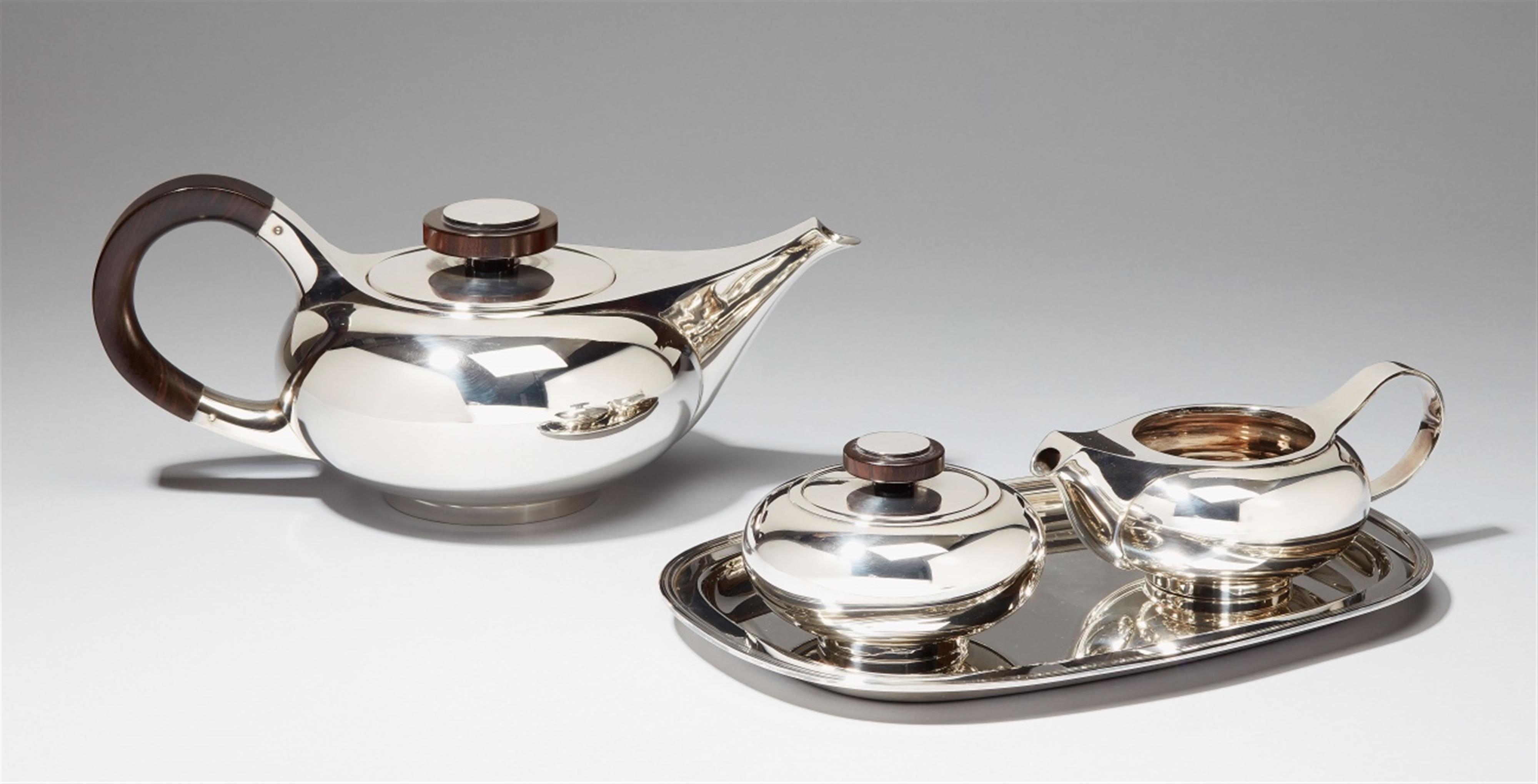 A Bremen silver tea service. Comprising teapot, milk jug, sugar box and small tray; the handles of grenadilla wood. Designed by Max Lorenzen, 1960s. - image-1