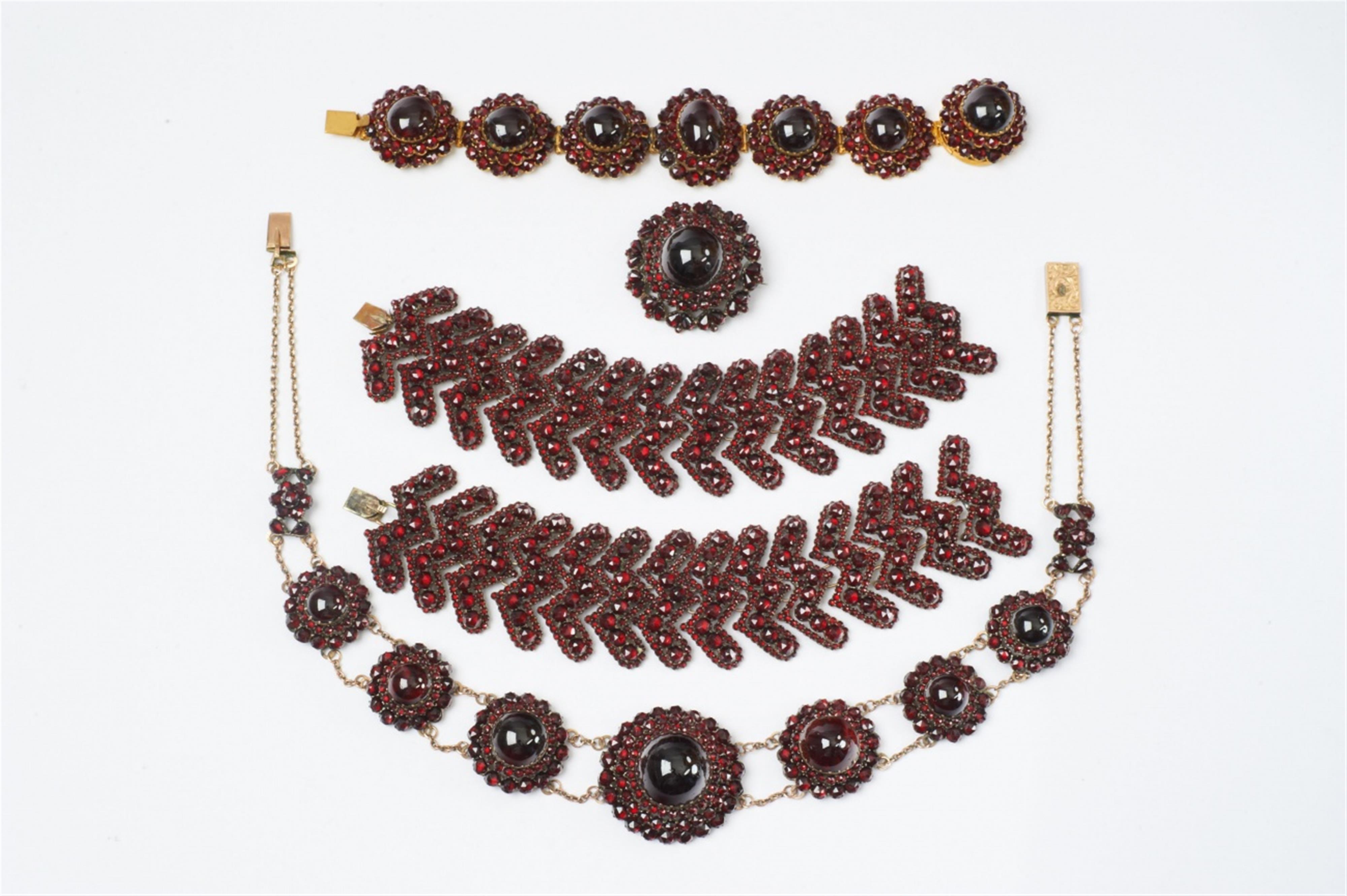 Five pieces of partially gilt tombac jewellery with Bohemian garnets - image-1