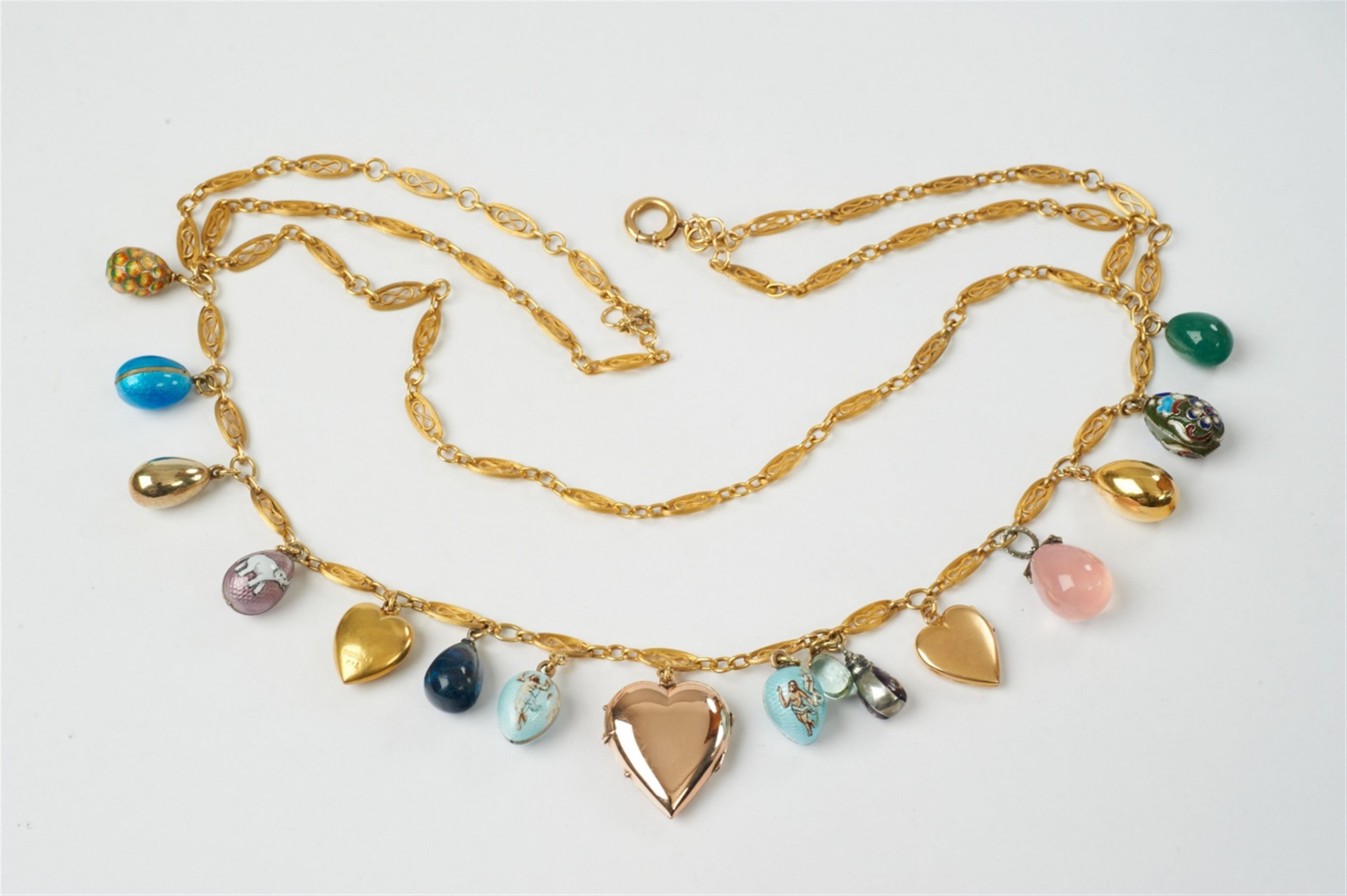A gold, silver, enamel, gem-set charm necklace with egg- and heart-shaped pendants - image-1