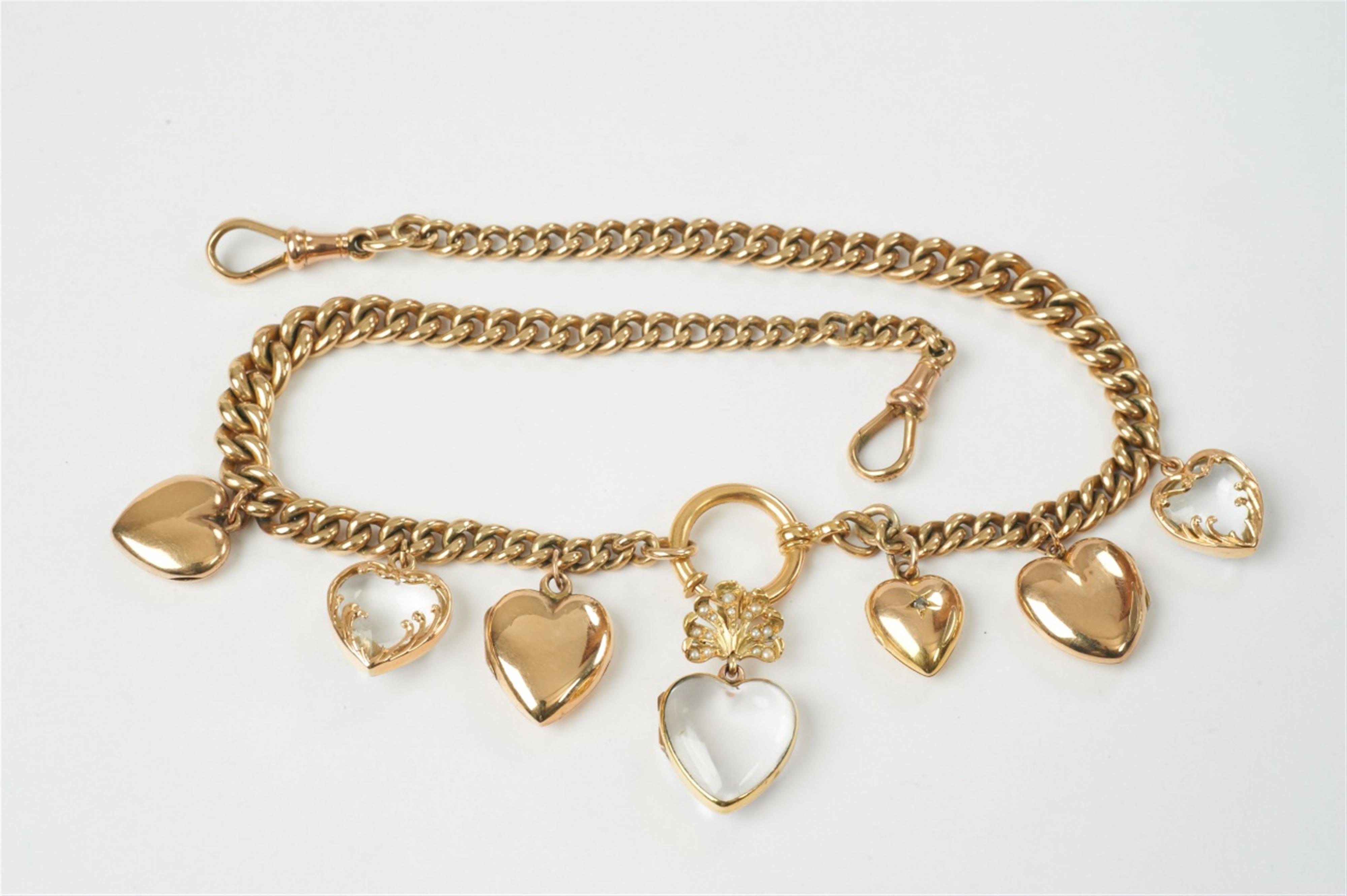 An Edwardian gold and rock crystal charm necklace with heart pendants - image-1