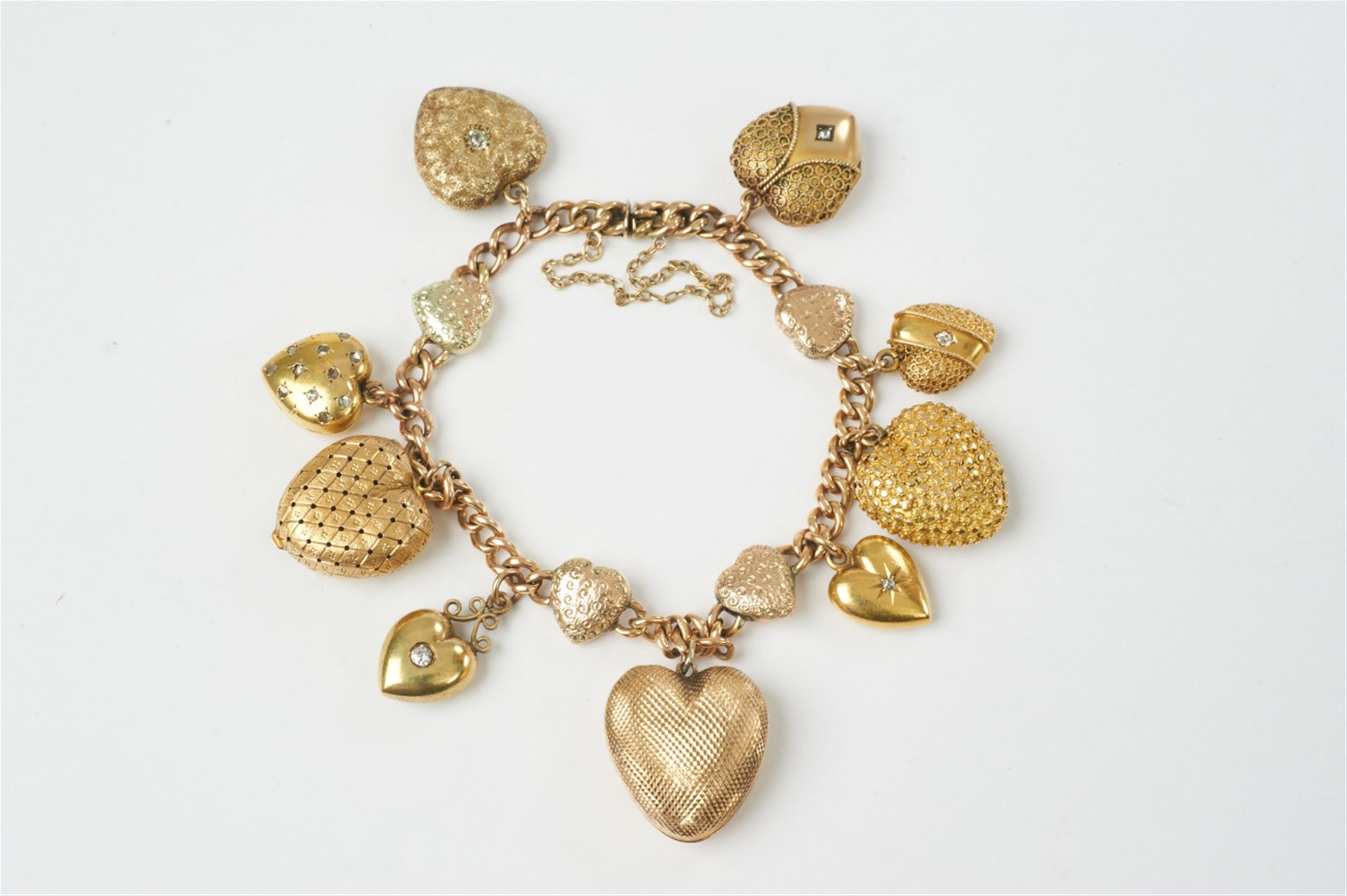 A Victorian 9 and 15k gold and diamond charm bracelet with heart pendants - image-1