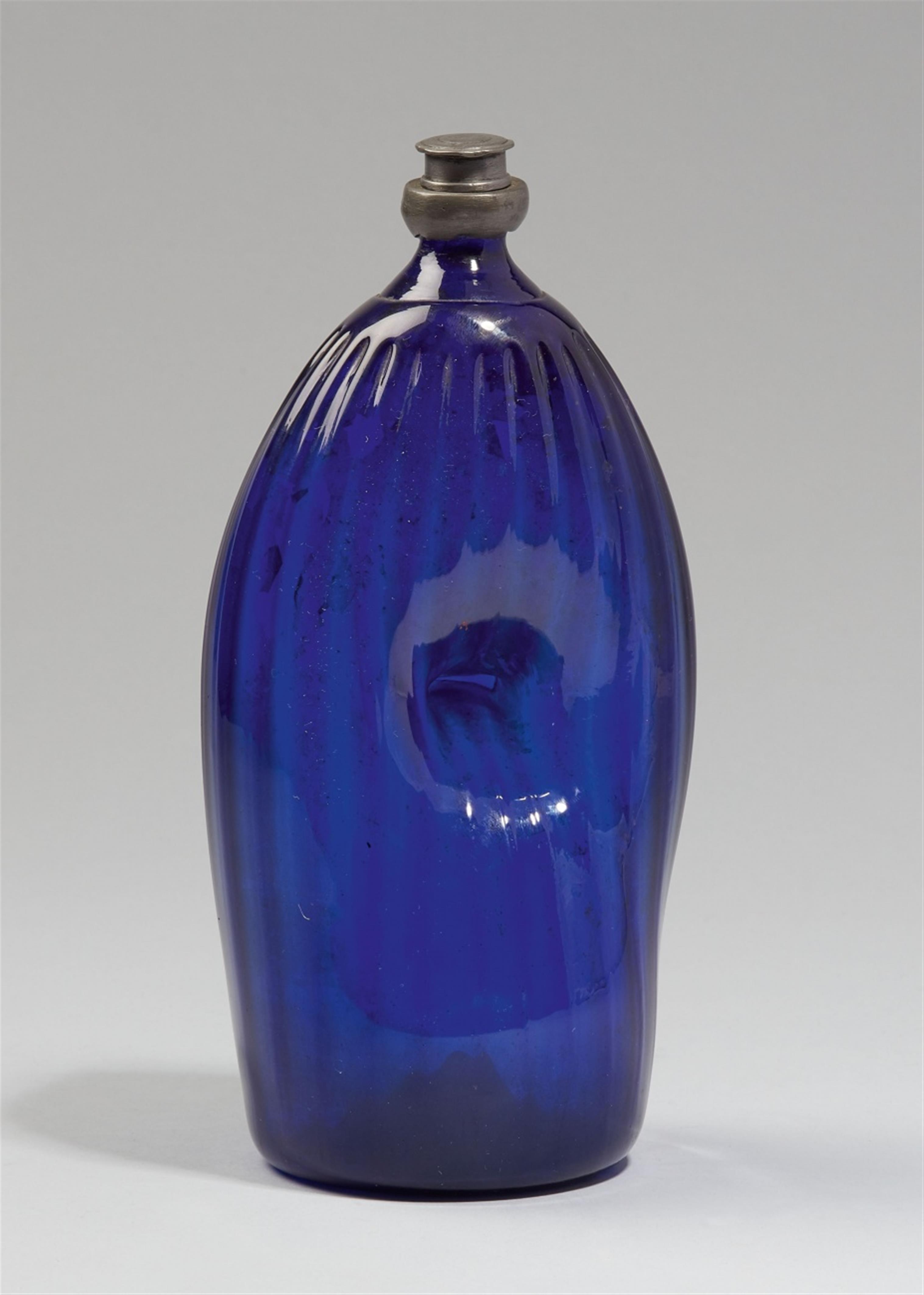 A tin-mounted ribbed blue glass bottle - image-1