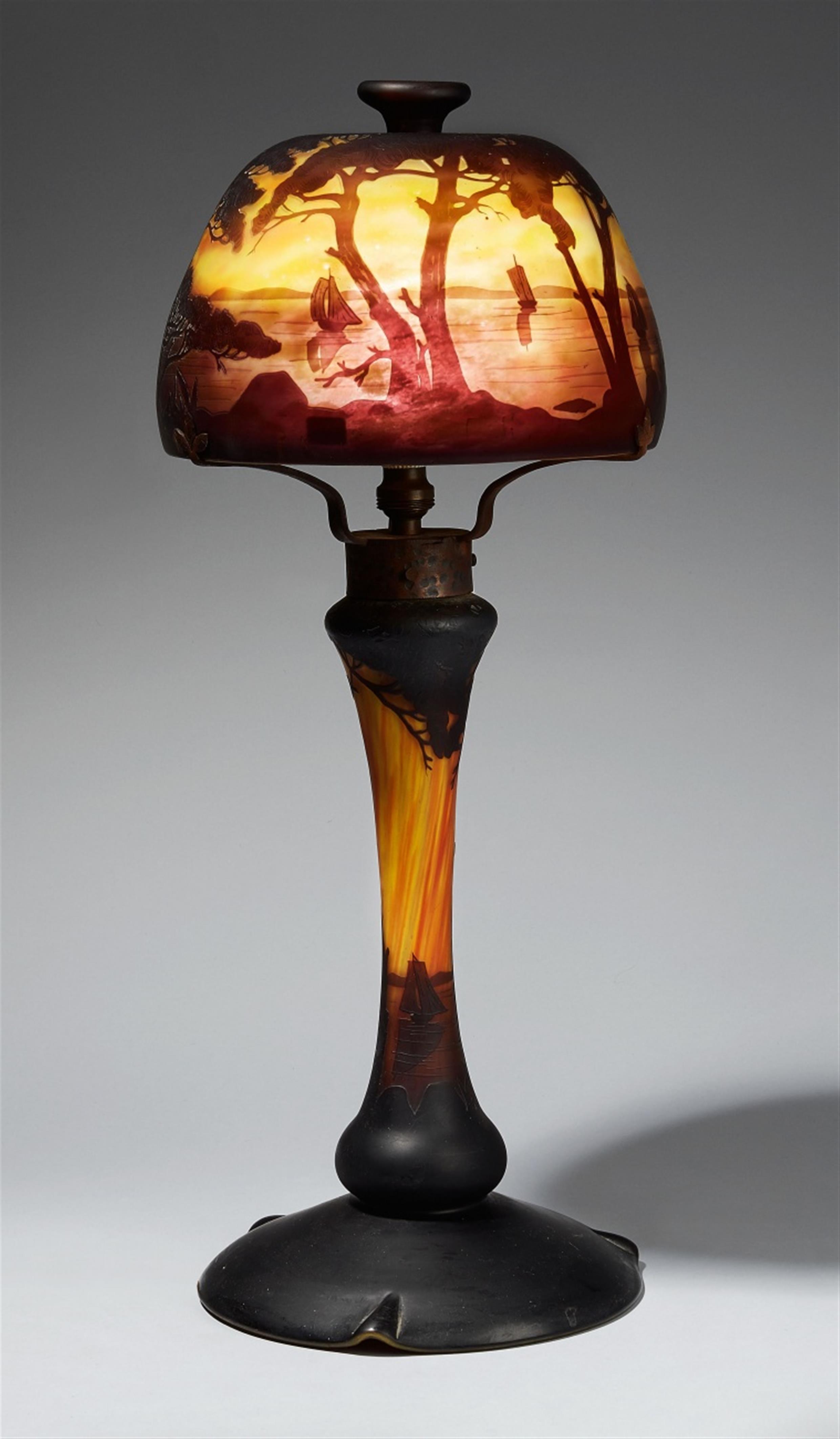 A Daum Frères 'paysage lacustre' etched overlay glass table lamp - image-1
