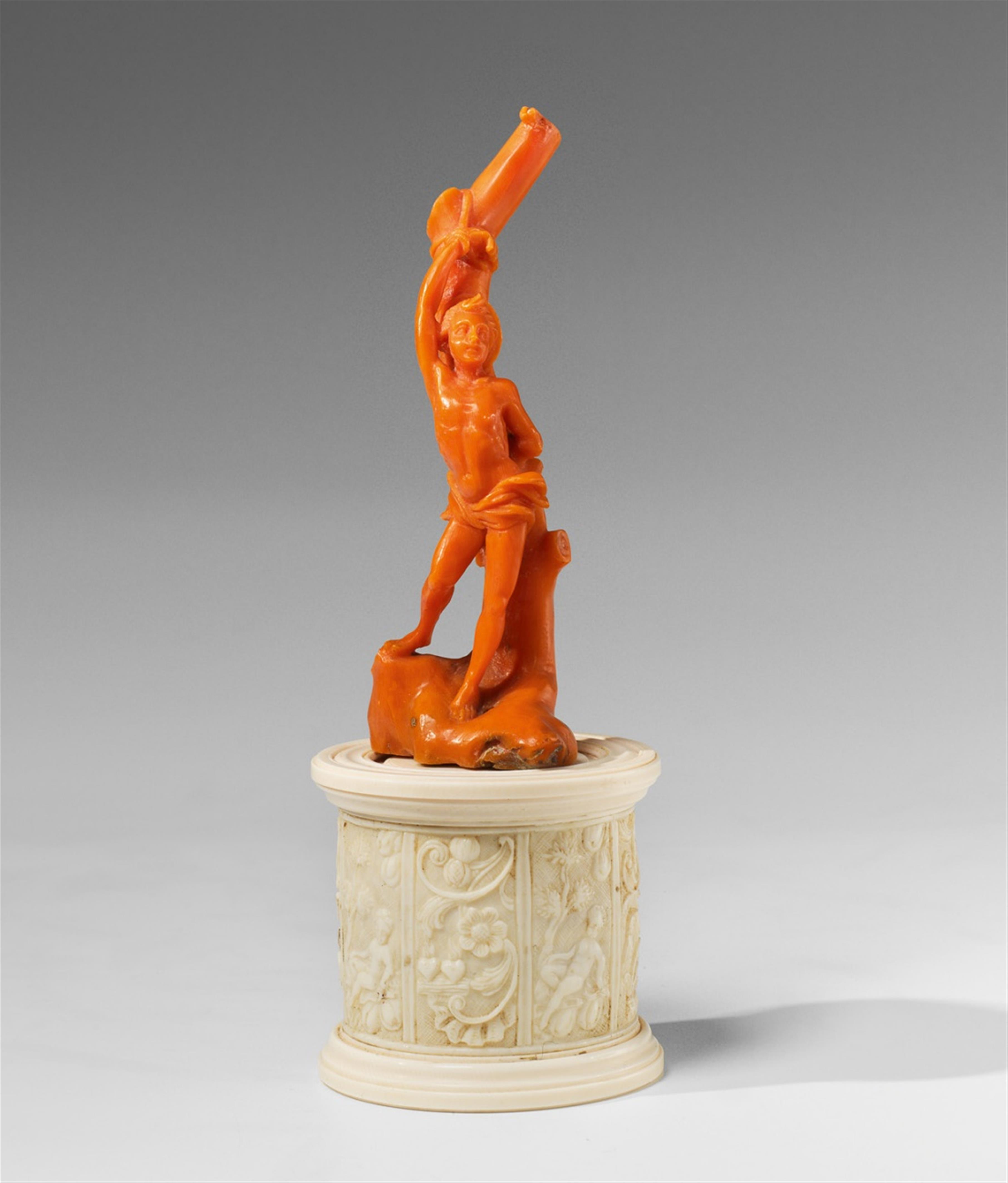 A carved red coral figure of Saint Sebastian on an ivory plinth - image-1