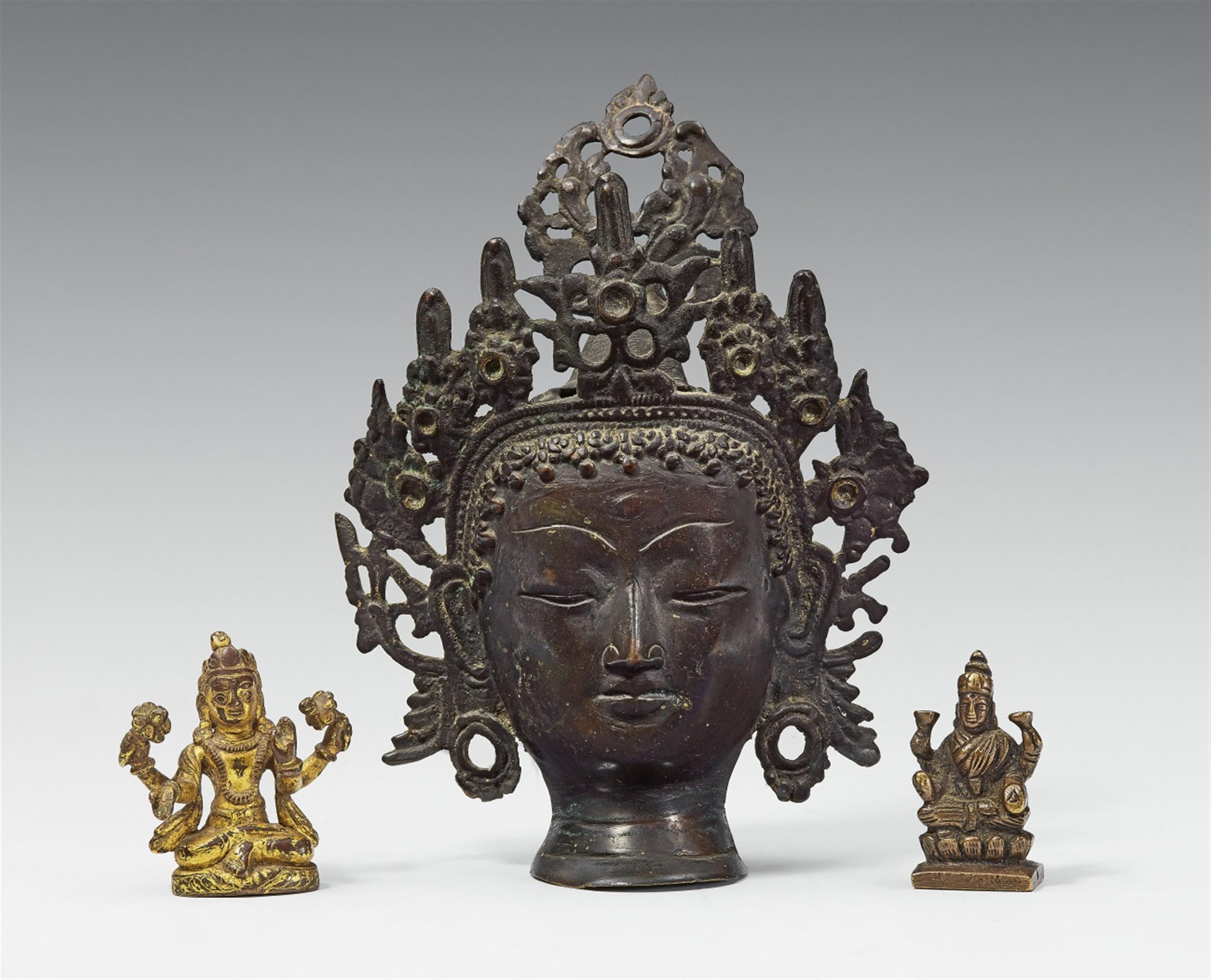 A group of a head of a deity and two miniature figures. Bronze. Tibet. 19th century and later - image-1