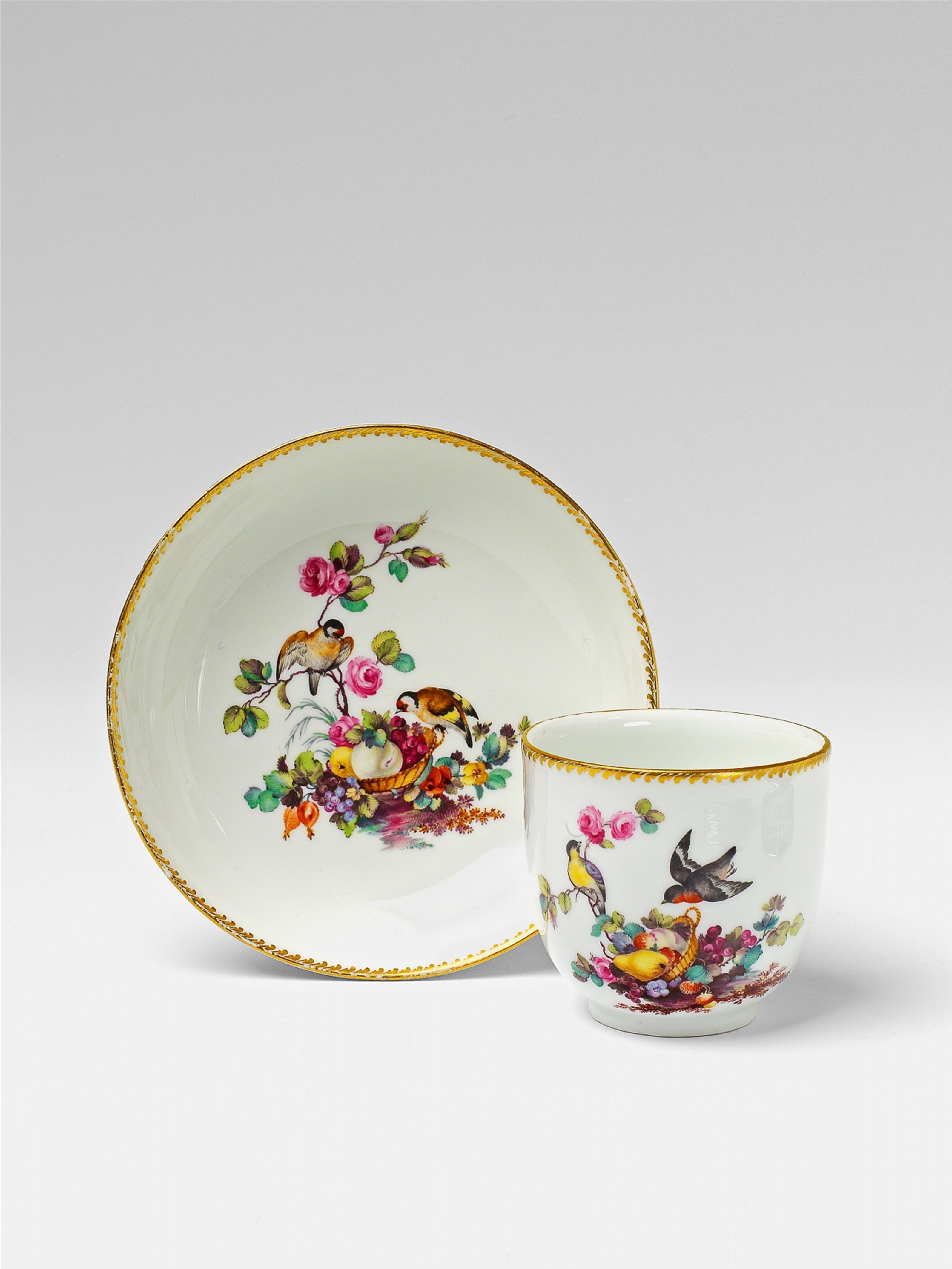 A Berlin KPM porcelain cup and saucer with birds and a basket of fruit - image-1