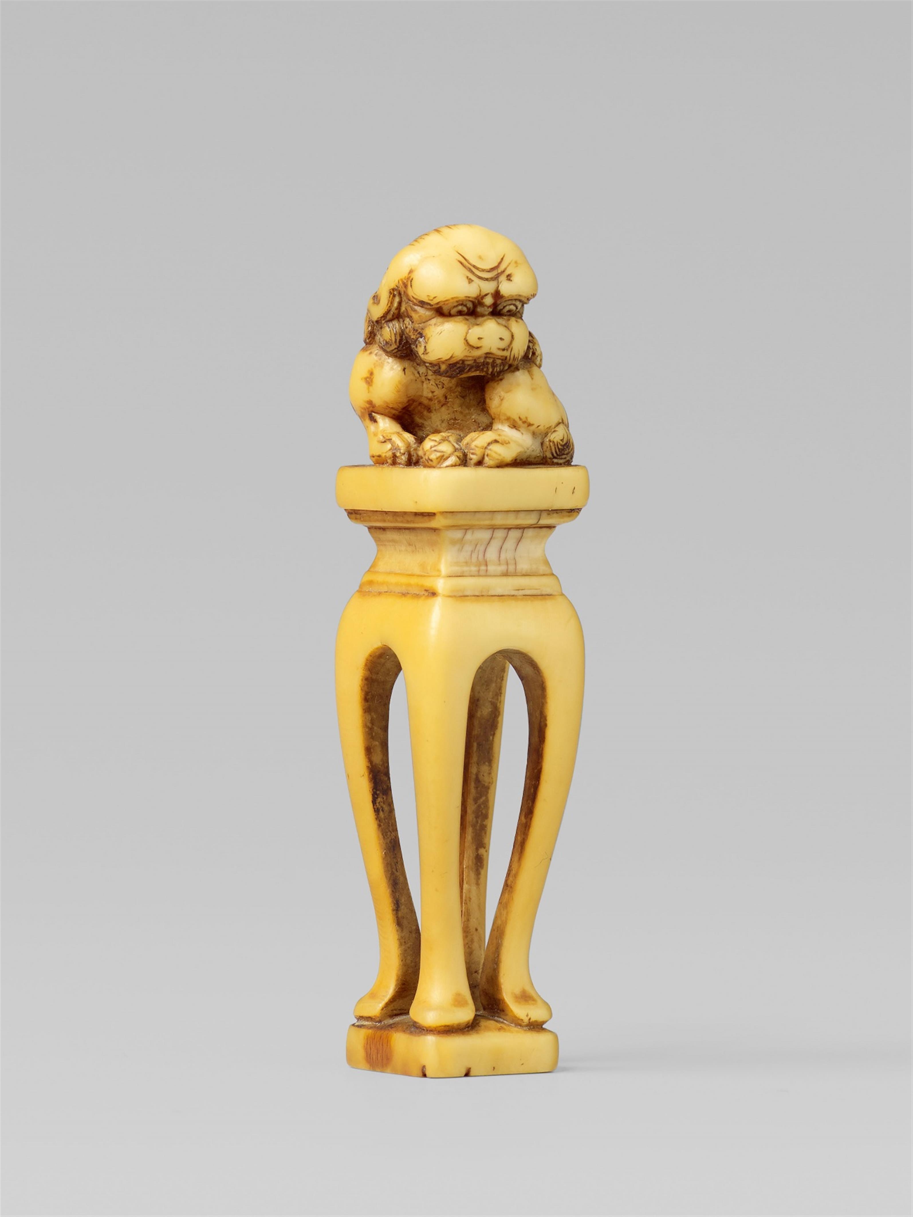 An ivory seal netsuke of a shishi on a high stand. 18th/19th century - image-1