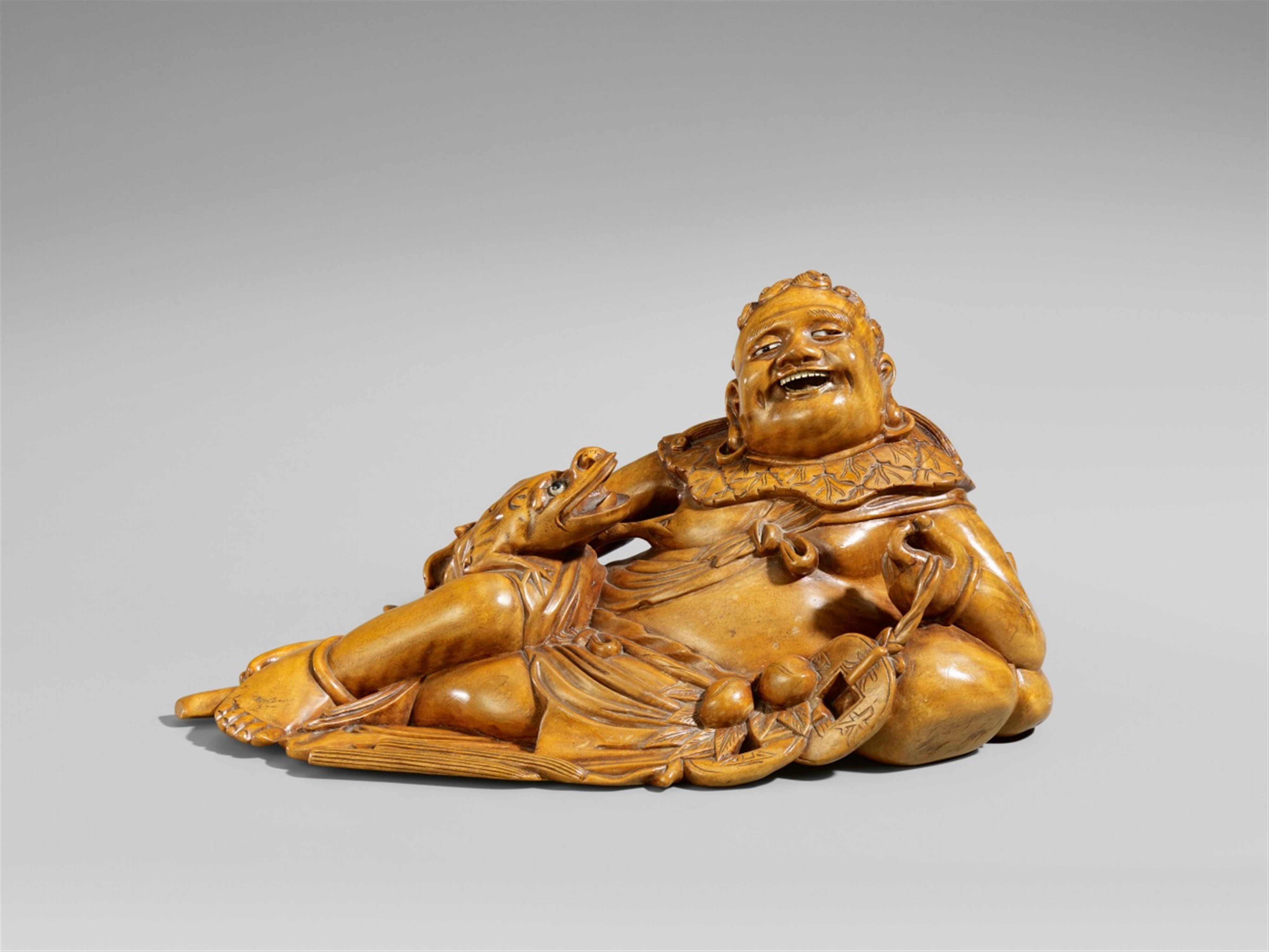 A wood figure of a reclining Liuhai Xian - image-1