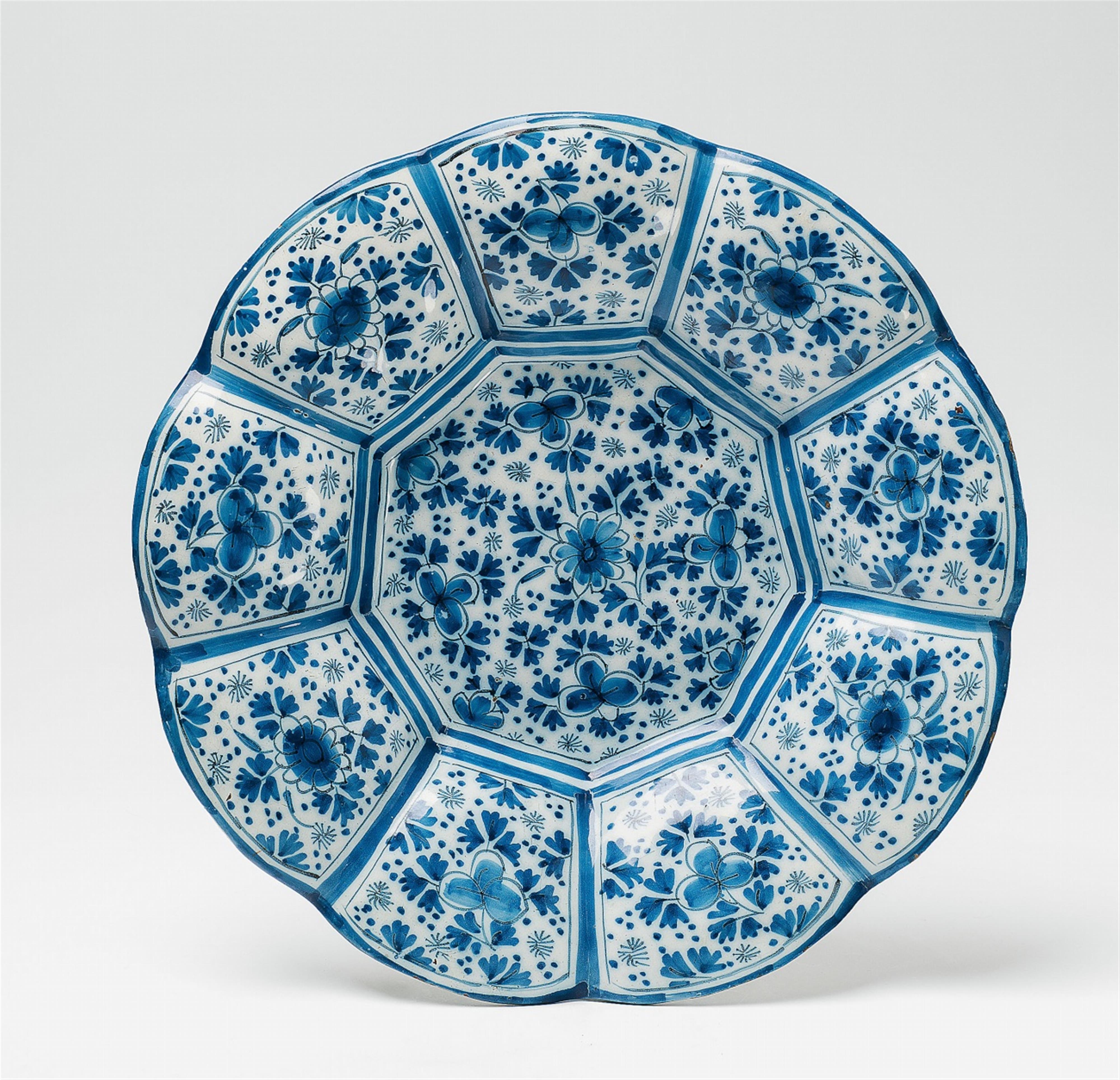 A gadrooned Delft faience charger with scattered flower decor - image-1