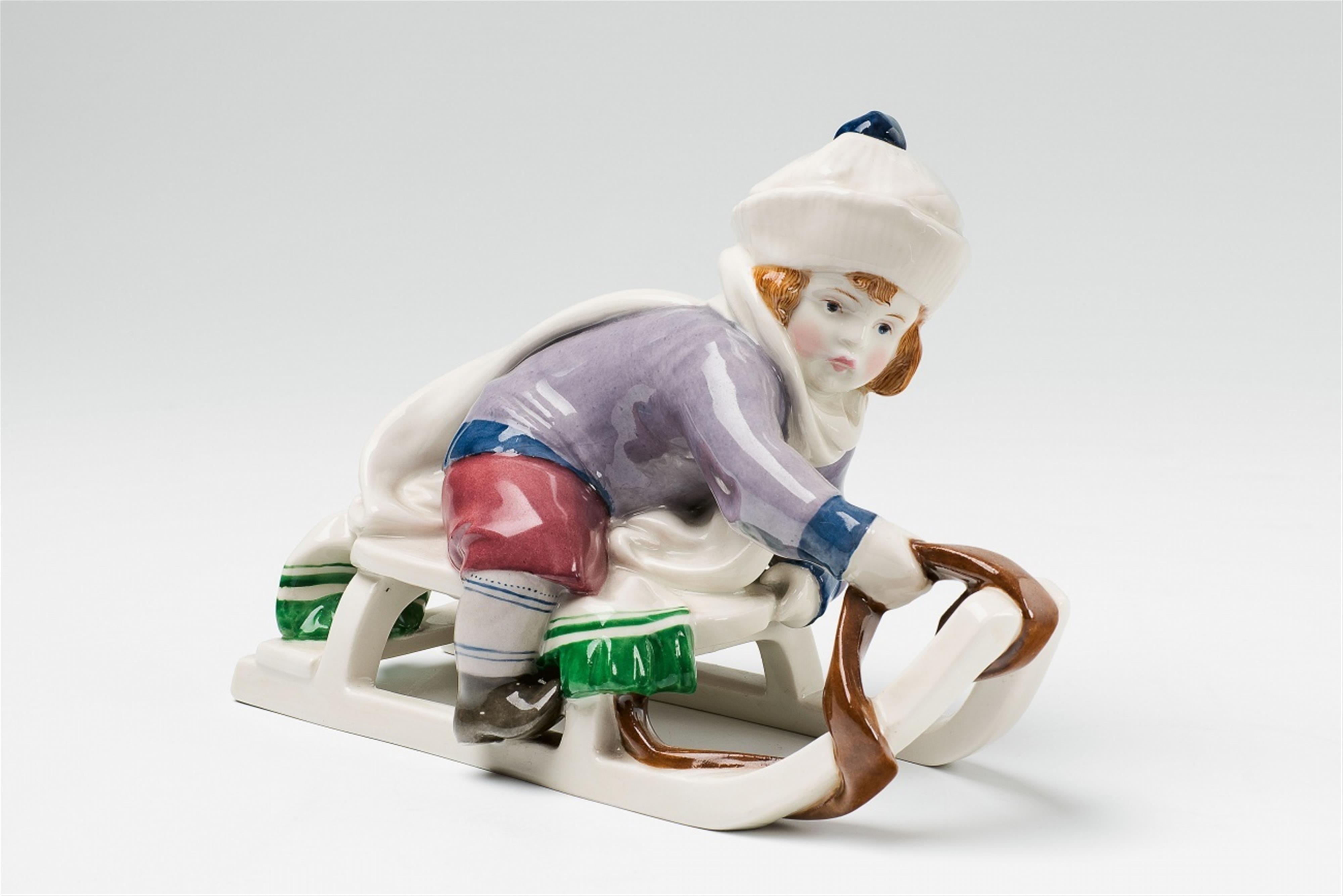 A Berlin KPM porcelain figure of a boy on a sledge - image-1