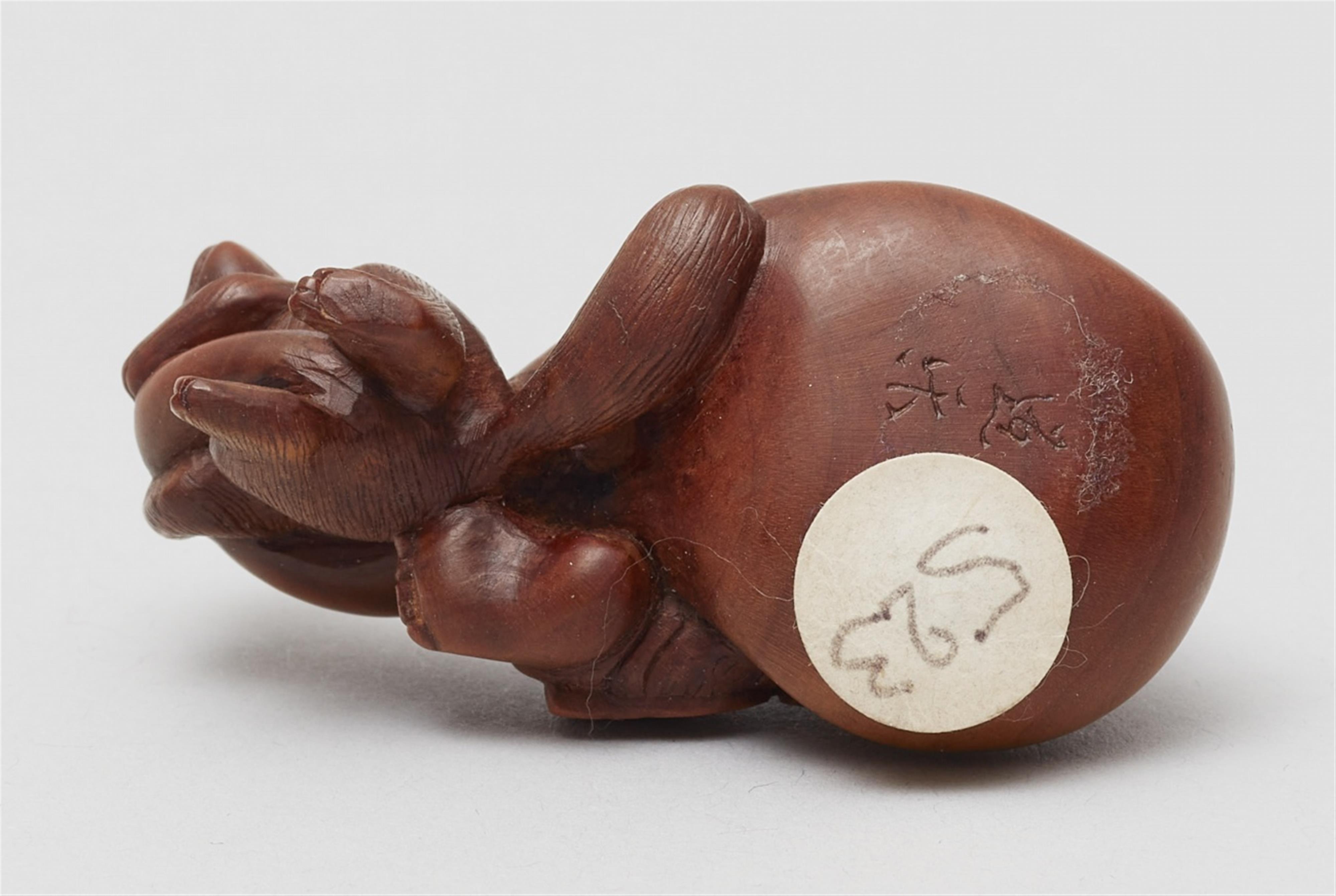 A boxwood netsuke of Hotei being pulled by a tanuki. 19th century - image-4