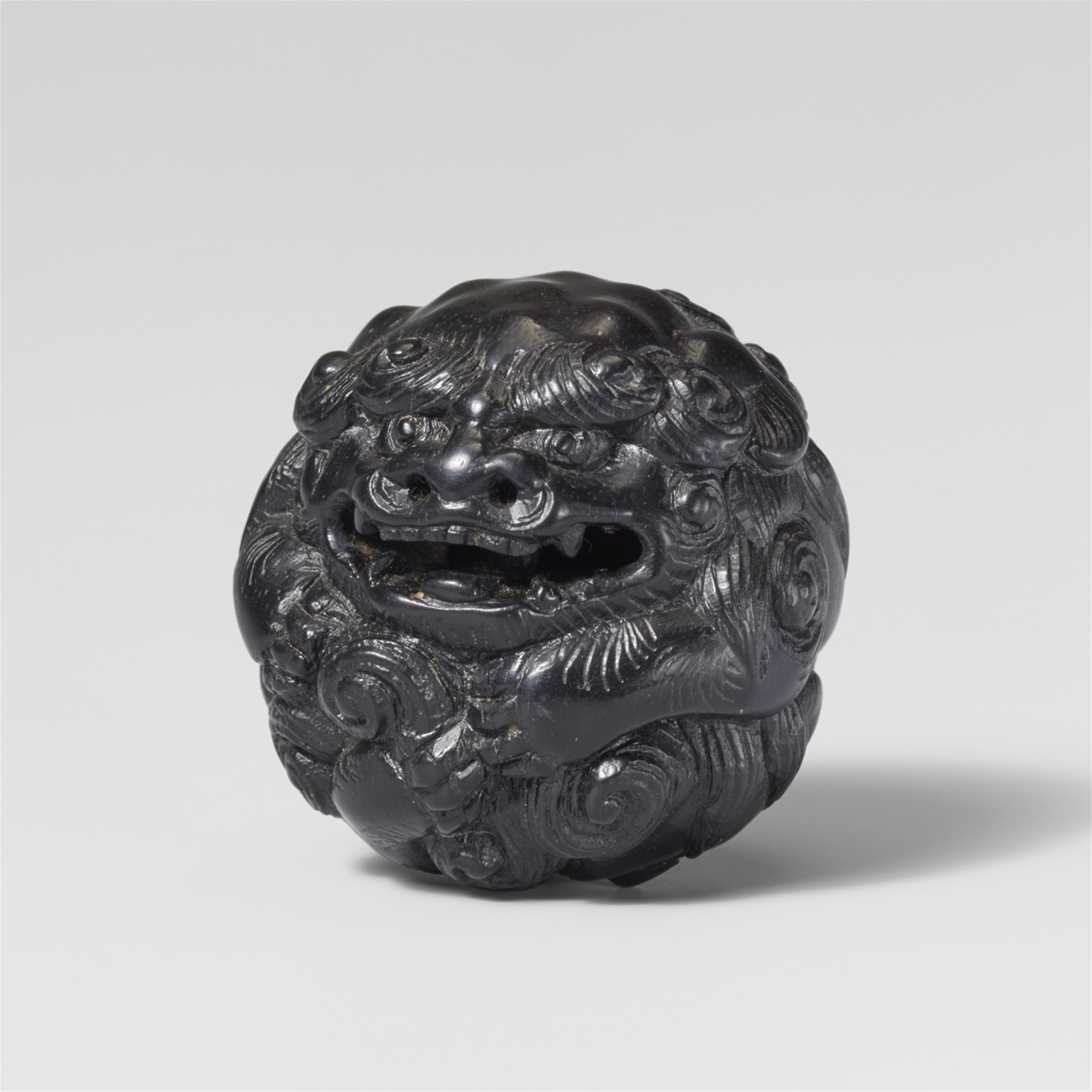 A rare and large ebony netsuke of a shishi rolled into a ball. Early 19th century - image-1
