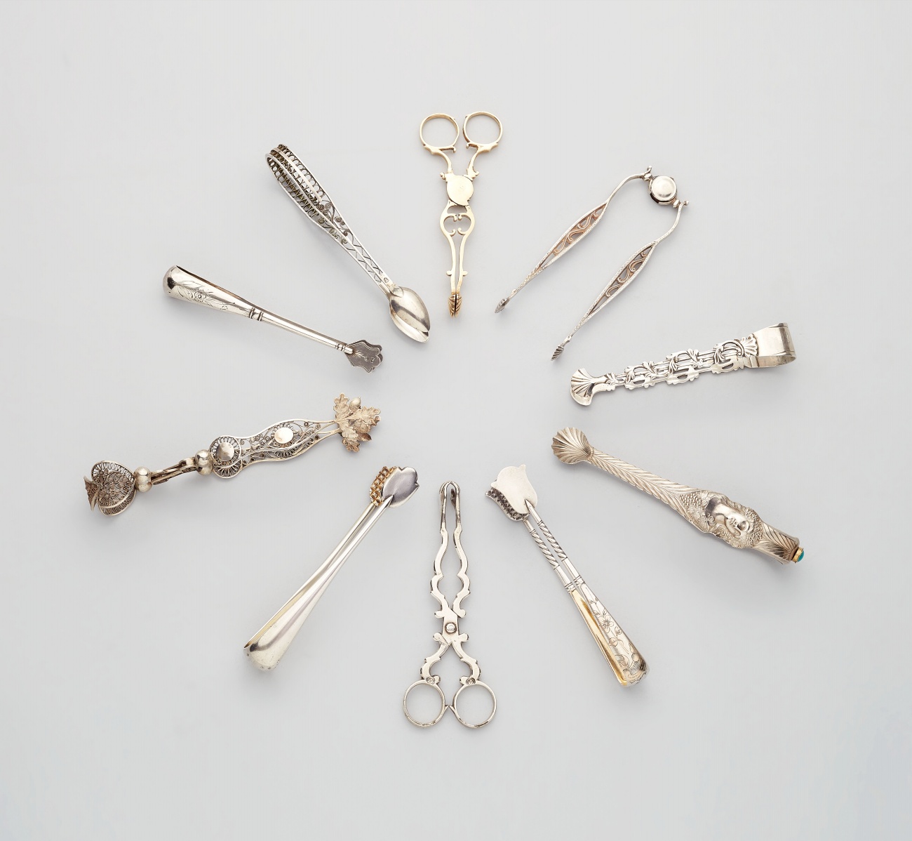 Ten silver sugar tongs, one by Fabergé. - image-1