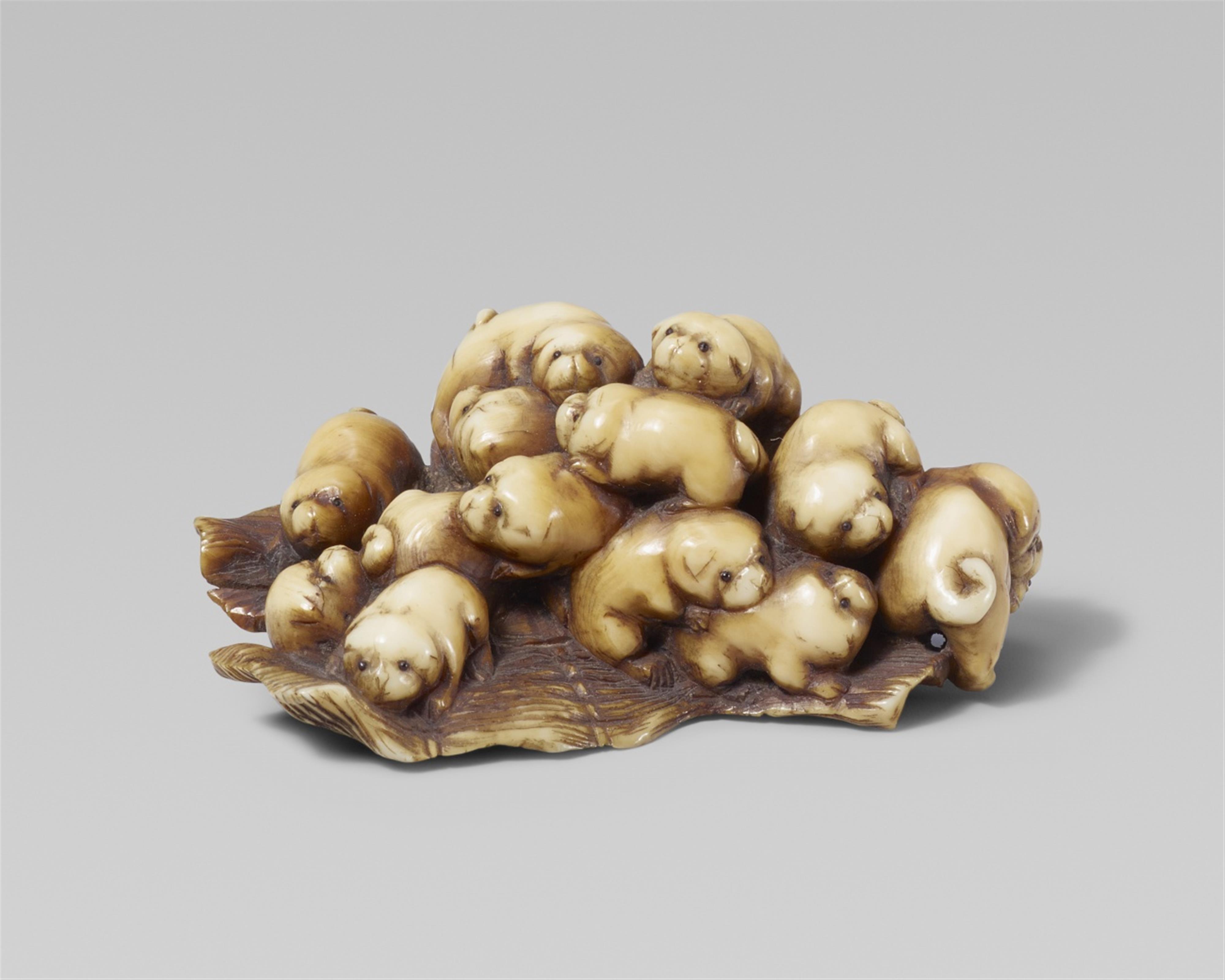 A stained ivory netsuke of a group of fifteen puppies. Late 19th century - image-1