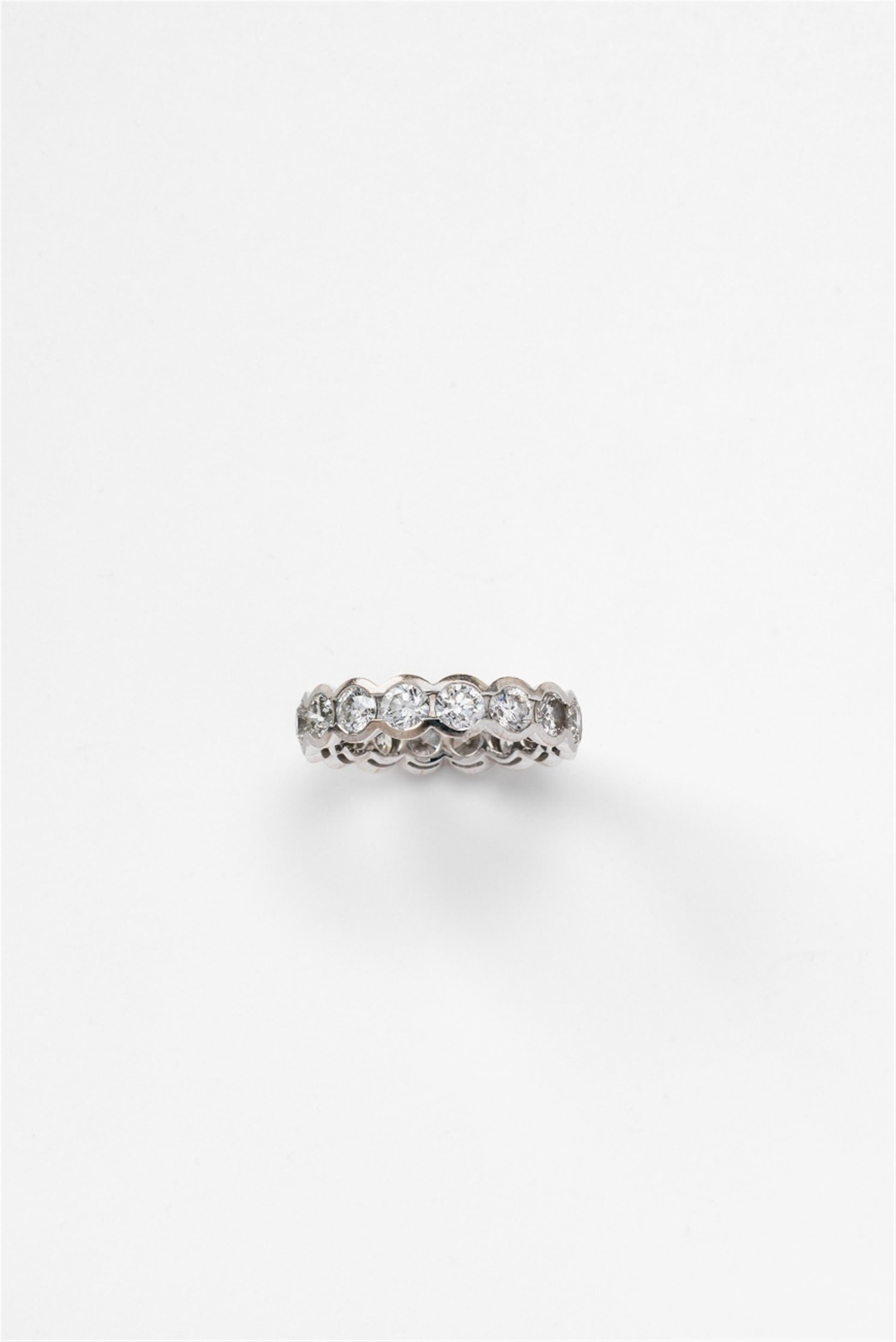 An 18k white gold and diamond eternity ring - image-1