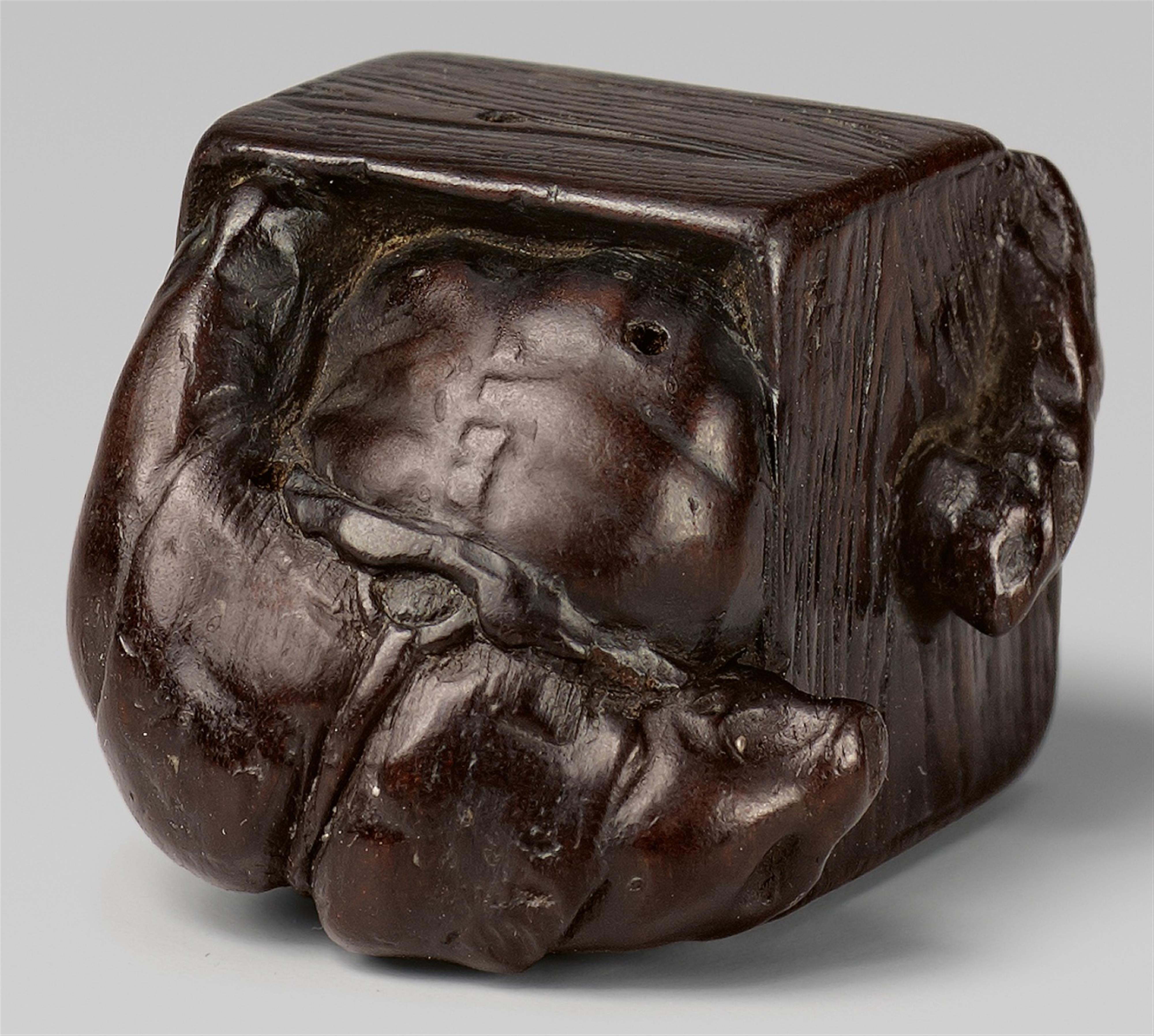 A dark wood netsuke of an oni in a portable heater. Mid-19th century - image-1