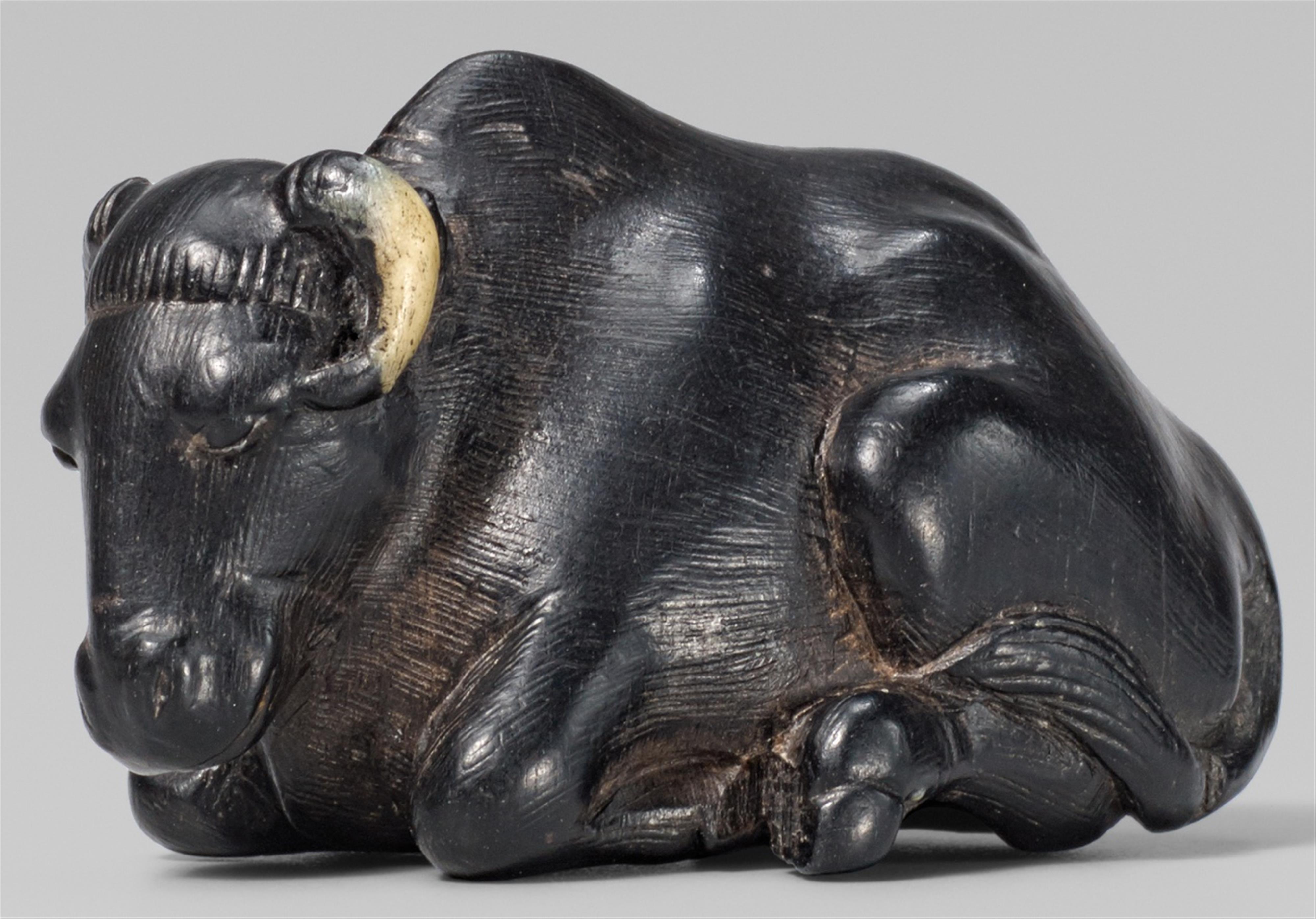 A fine small ebony wood netsuke of a recumbent ox. 19th century - image-1